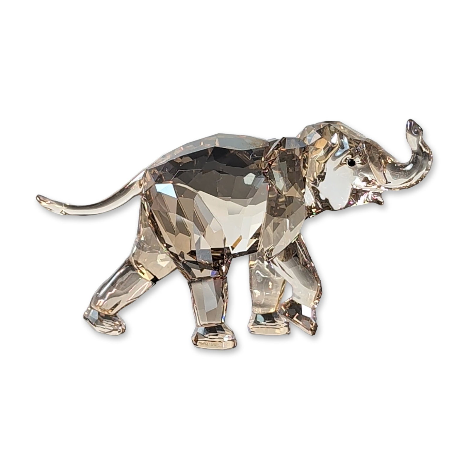 Swarovski SCS Golden Shadow Crystal Young Elephant: A Swarovski Crystal Society (SCS) 2013 "Young Elephant" figurine, designed by Elisabeth Adamer (Model 1142862). This exclusive piece is expertly rendered in faceted Light Sand crystal and features an 