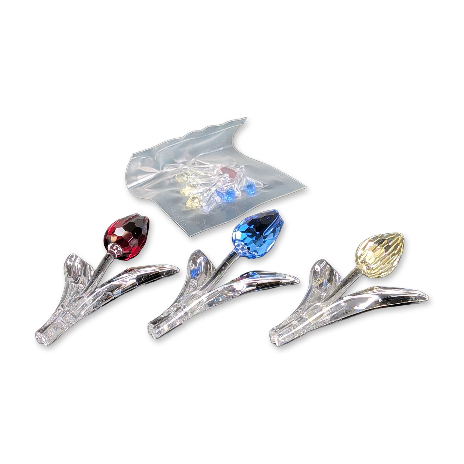 Trio of Swarovski Crystal Figurines, Tulips and Loose Tulip Crystals: Swarovski. Trio of tulip figurines from the Flower Dreams collection, crafted in faceted clear and colored lead crystal. The set includes three individual flowers in yellow, ruby red, and light blue, 