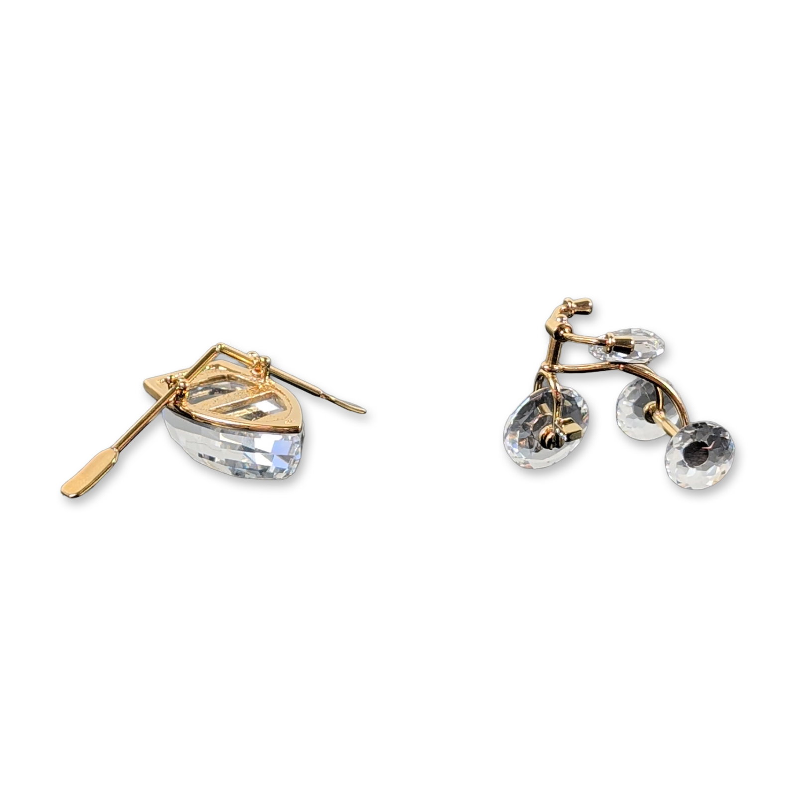 2pc Swarovski Crystal Memories Figurines: Swarovski. Pair of figurines from the Crystal Memories collection in faceted lead crystal and gold-tone metal. The group includes a rowboat with a faceted hull and single oar, and a crystal bicycle Th