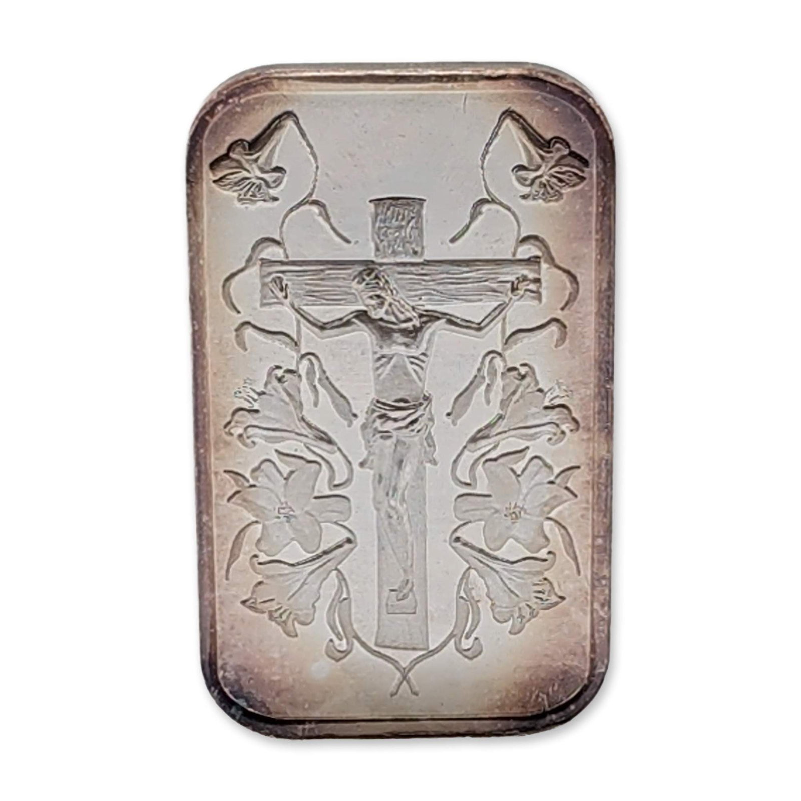 Jesus on the Cross 1oz .999 Fine Silver Bullion Uncirculated: Jesus on the Cross bullion bar struck in .999 fine silver, containing one troy ounce of fine silver. The obverse features a detailed depiction of the crucified Christ surrounded by stylized lily flowe