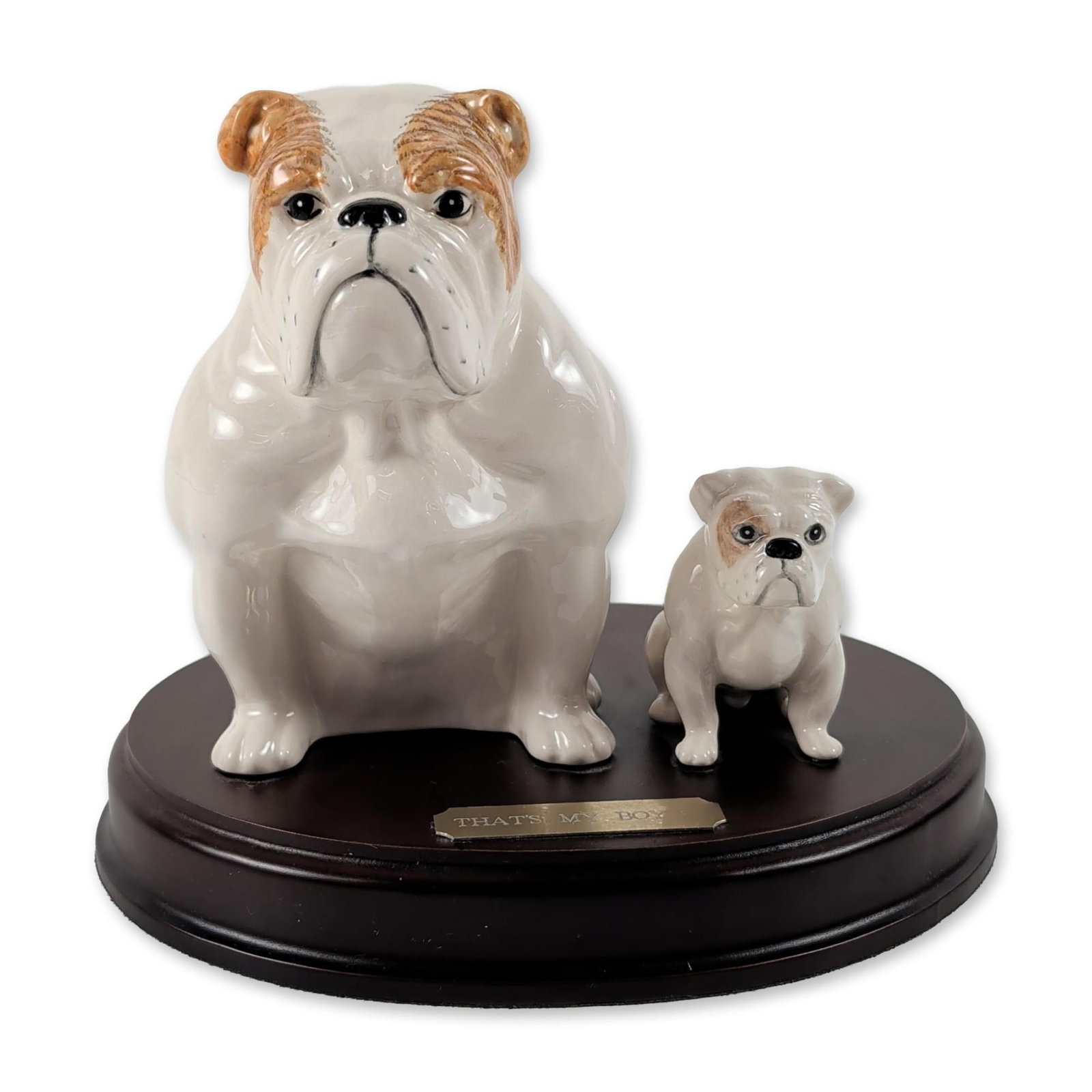 Royal Doulton Thats My Boy Bulldog Figurine: Royal Doulton porcelain figurine titled Thats My Boy, model DA222. Features a seated adult English bulldog and a puppy, both crafted in glazed porcelain. The figures are finished in white with brown b