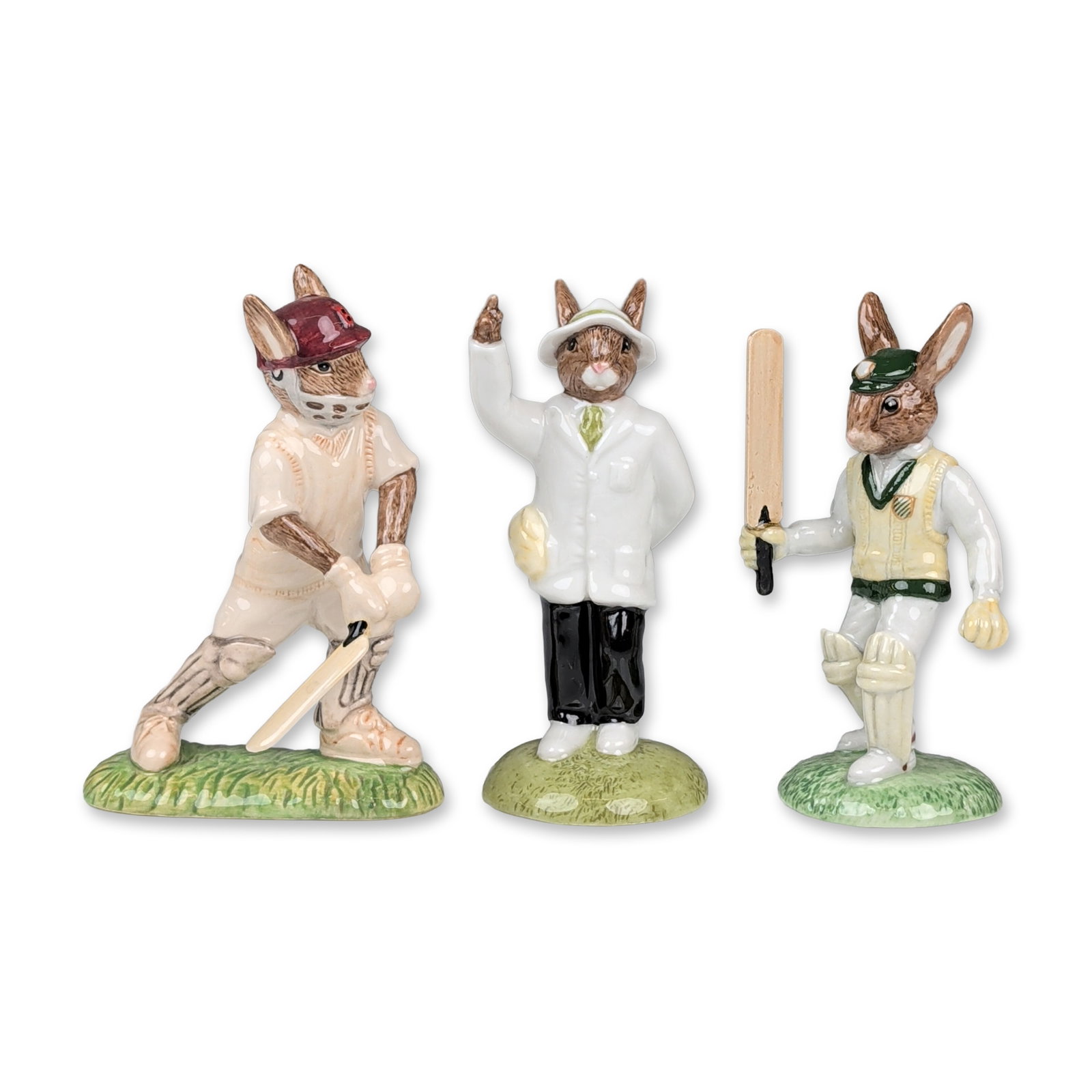 Trio of Royal Doulton Bunnykins Cricket Figurines: Royal Doulton. Trio of hand-decorated ceramic figurines from the Bunnykins cricket series. The group comprises Test Century Bunnykins (DB 272), Umpire Bunnykins (DB 360), and Out For A Duck (DB 448). 