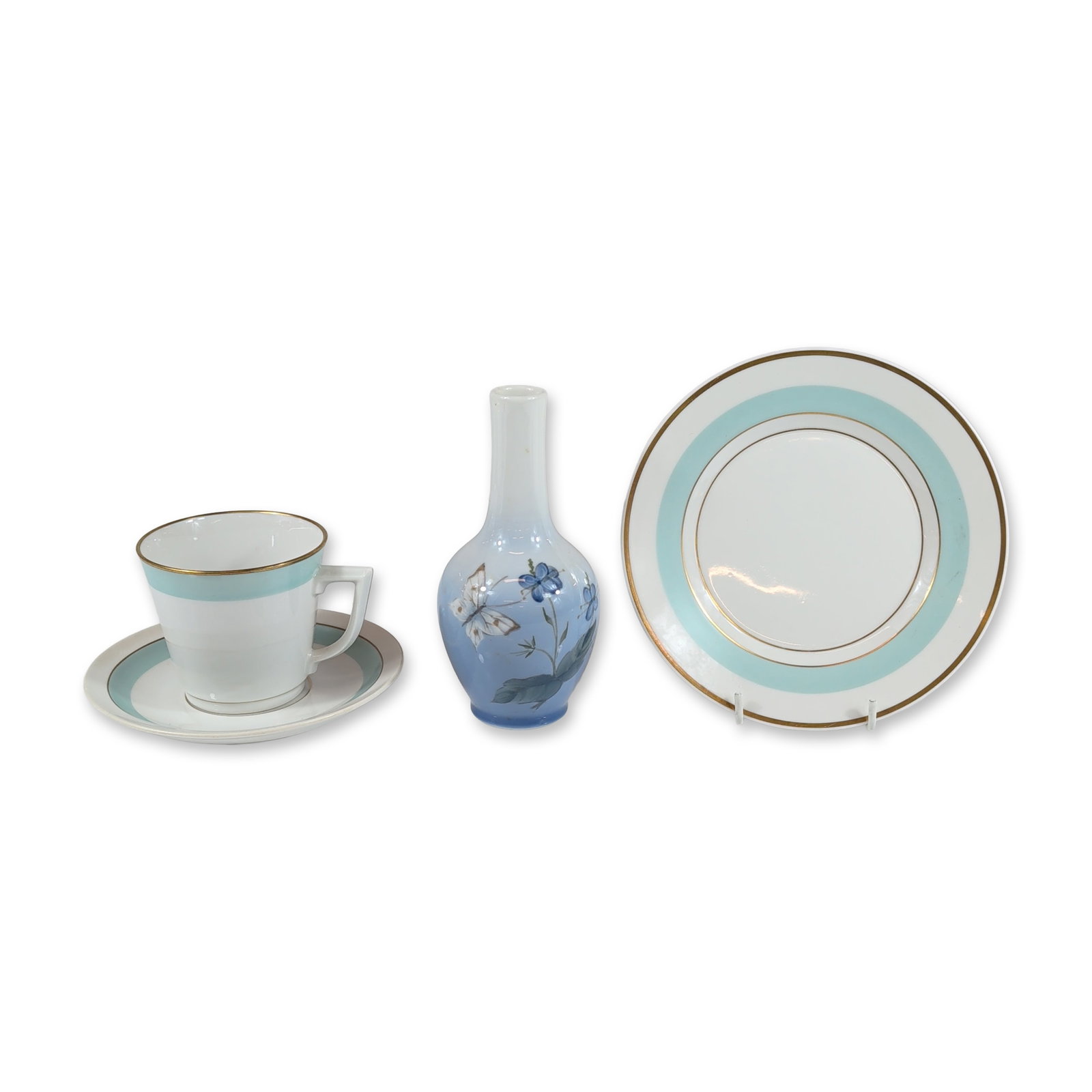 4pc Royal Copenhagen Danish Porcelain Collection: Royal Copenhagen, Denmark. Collection of porcelain tableware and decorative items featuring a cup, saucer, side plate, and miniature bud vase. The tea service pieces display a white ground accented wi