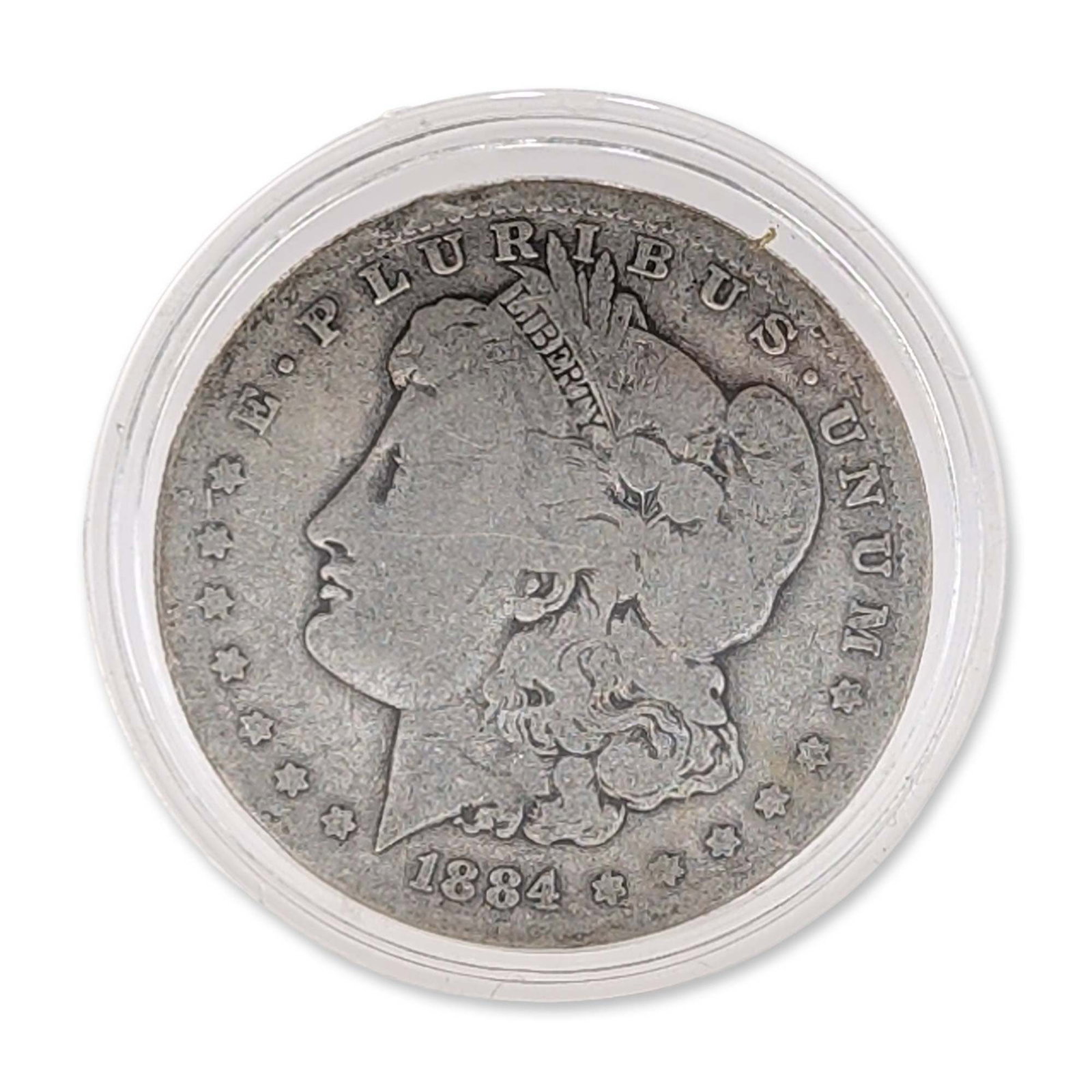 US 1884 Morgan Silver Dollar: 1884 United States Morgan silver dollar. Coin in 90% silver, struck at the Philadelphia mint. Features standard Morgan obverse and reverse designs. Absence of mint mark on reverse. Housed in a clear p
