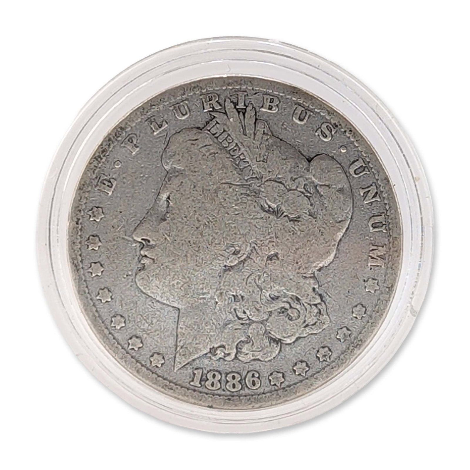 US 1886 Philadelphia Morgan Silver Dollar: US 1886 Morgan silver dollar, minted in Philadelphia. Struck in 90% silver. The coin features the standard obverse and reverse designs by George T. Morgan and is housed in a clear plastic circular cap
