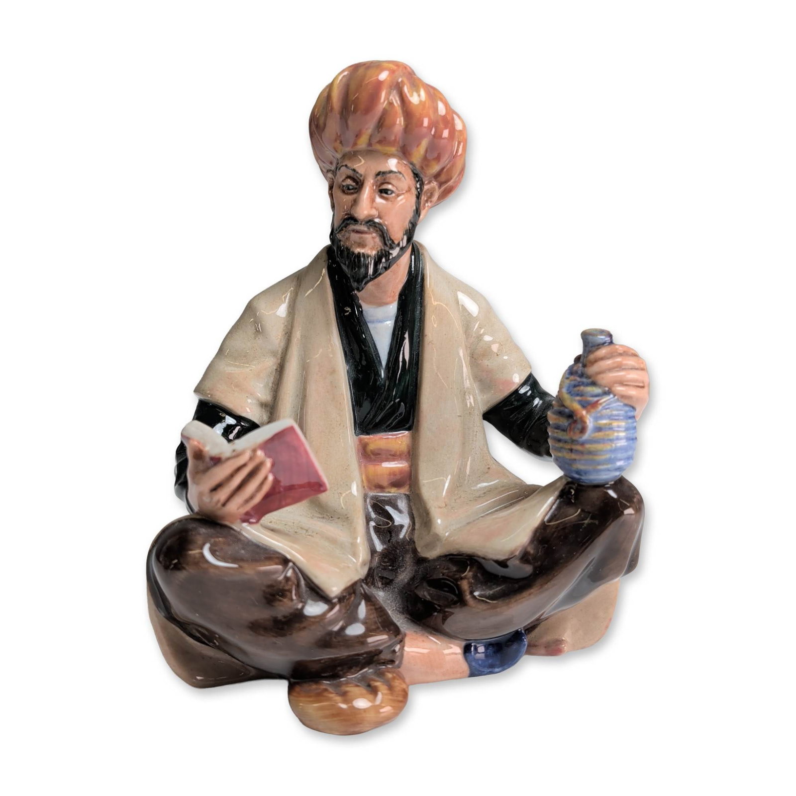 Royal Doulton Omar Khayyam Figurine HN 2247: Royal Doulton porcelain figurine titled Omar Khayyam, model HN 2247. The figure depicts the Persian polymath and poet seated cross-legged wearing a polychrome turban, a cream robe over a dark vest, an