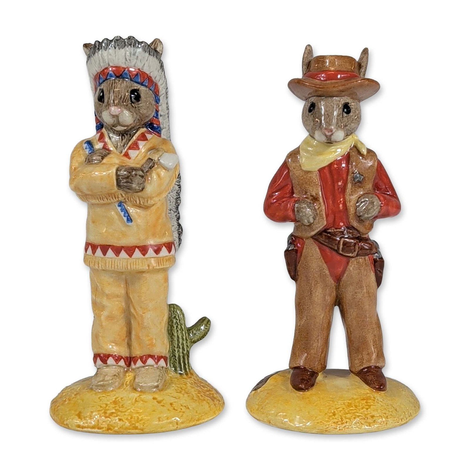 2pc Royal Doulton Wild West Bunnykins: Royal Doulton. Pair of glazed ceramic figurines from the Wild West series, comprising Cowboy Bunnykins and Indian Bunnykins. Cowboy Bunnykins is depicted in Western attire including a brown hat, red s