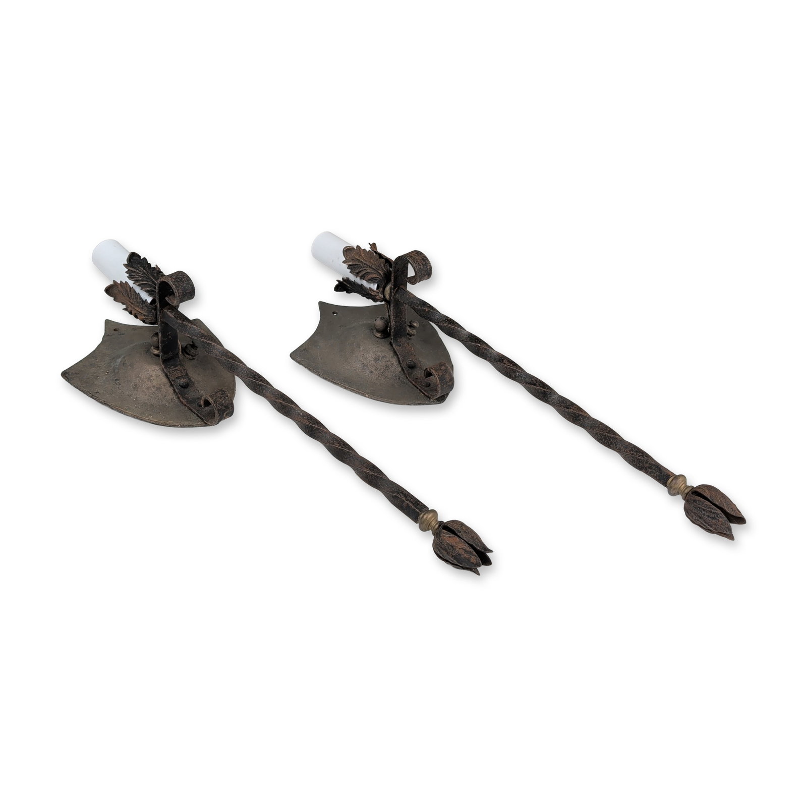 Pair of Wrought Iron Shield Wall Sconces: Matched pair of electric wall sconces in hand-wrought iron with a dark, textured patina. Each sconce features a shield-shaped backplate with a hammered surface supporting a single long,