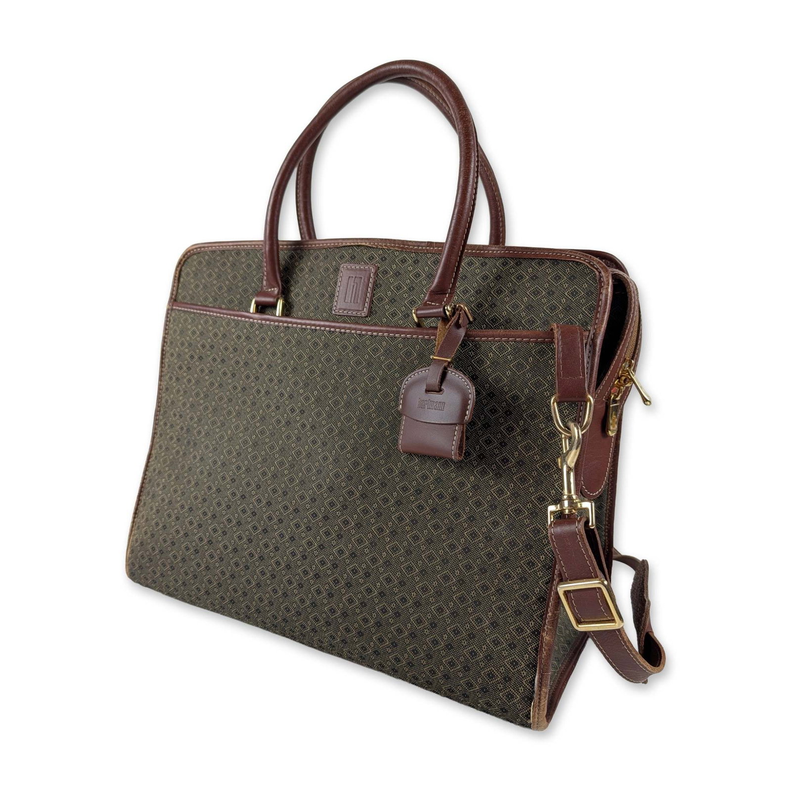 Hartmann Wings Diamond Jacquard Briefcase: Hartmann Wings collection briefcase in olive and tan diamond pattern jacquard canvas with brown leather trim. Features dual top handles, a removable shoulder strap, and gold-tone hardware. The