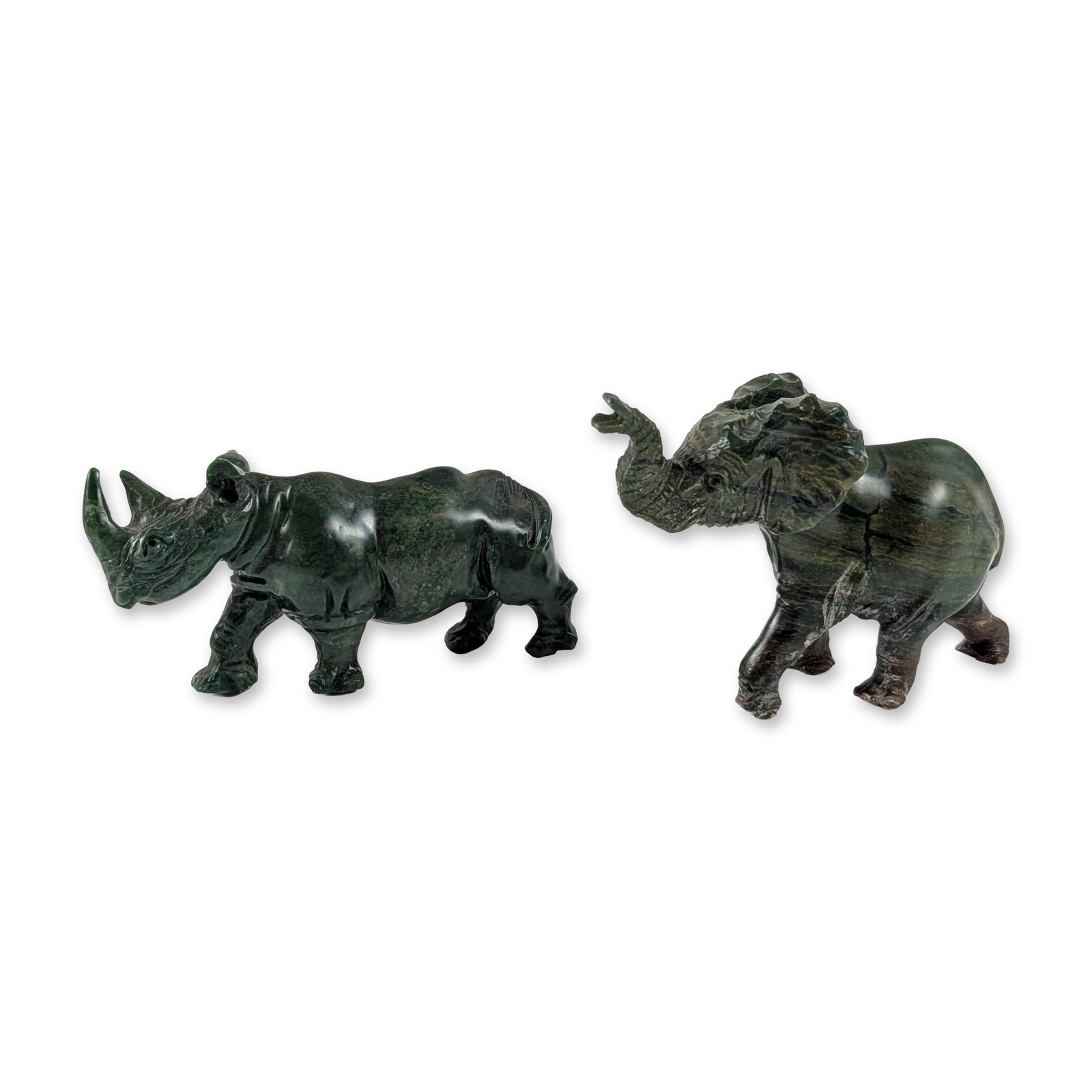 Two Zimbabwean Shona Verdite Stone Animal Sculptures: Zimbabwean Shona school. Two hand-carved verdite stone animal sculptures, including a rhinoceros and an elephant. The rhinoceros is depicted in a walking stance with two horns and a textured surface. 