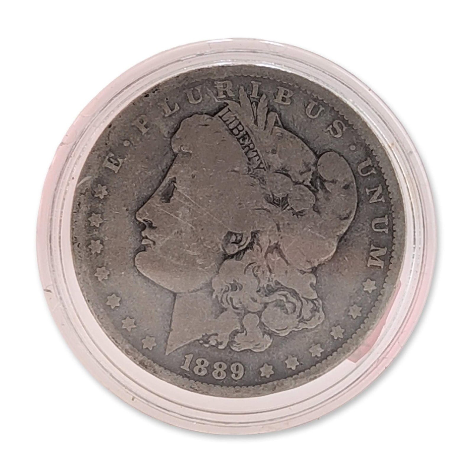 US 1889 Morgan Silver Dollar: US Morgan silver dollar, dated 1889, minted at the Philadelphia Mint. Coin composed of .900 fine silver. Featuring the Liberty head obverse design and the eagle within a laurel wreath on the reverse. 