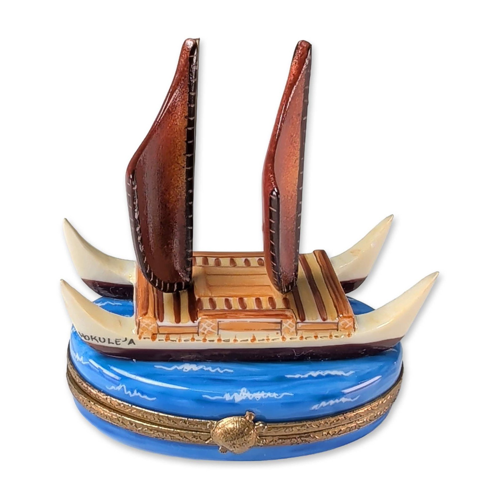 Limoges Carenton Porcelaine Hokulea Voyaging Canoe Box: Limoges hand-painted porcelain trinket box by Carenton Porcelaine. The piece features a three-dimensional model of the Polynesian voyaging canoe Hokulea mounted on a blue wave-patterned lid. The canoe