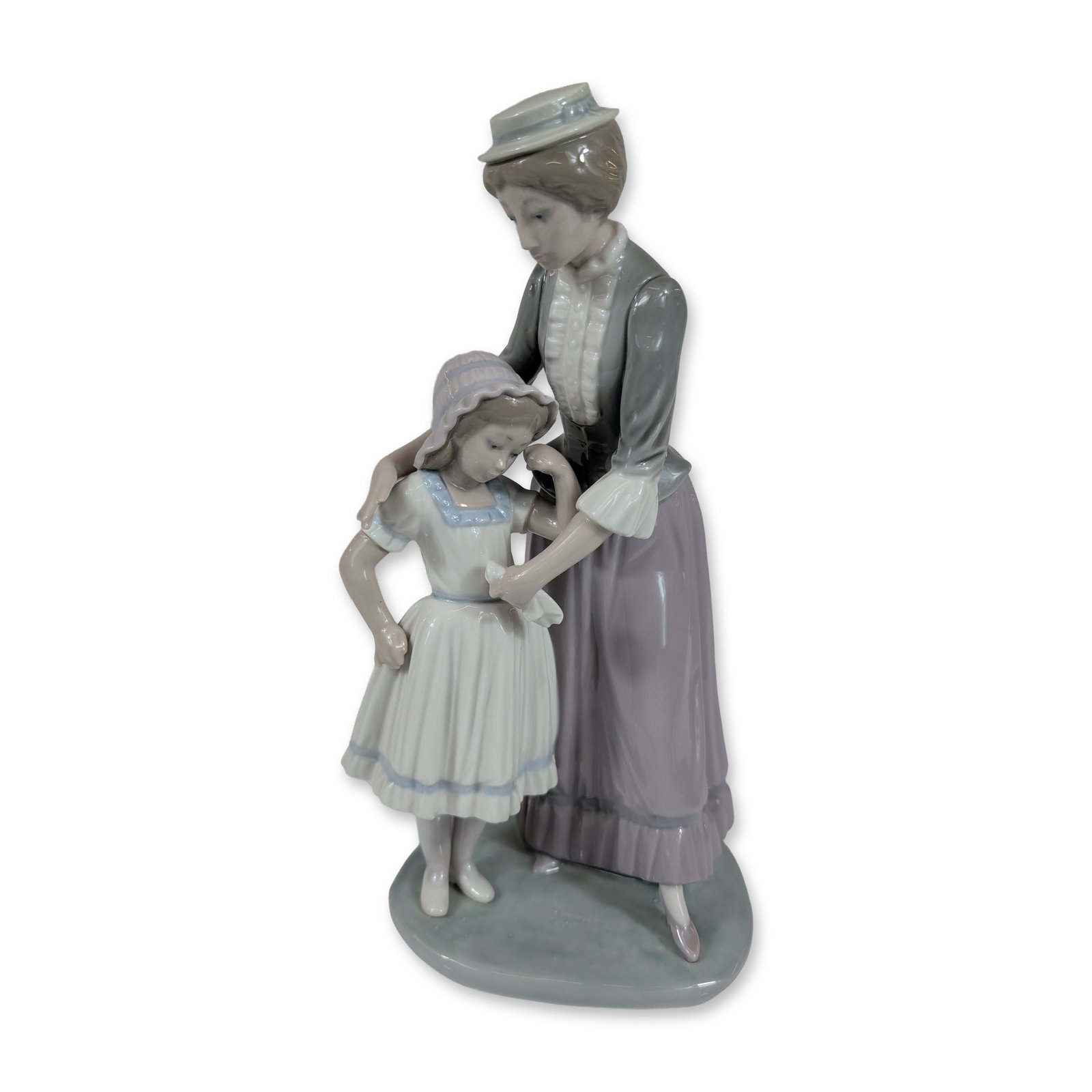 Lladro Solace Porcelain Figurine Number 5142: Lladro, Spain. Glazed porcelain figurine titled Solace, model number 5142, designed by Jose Puche. The piece depicts a mother and daughter in Edwardian-style attire; the woman in a gray tailored jacke