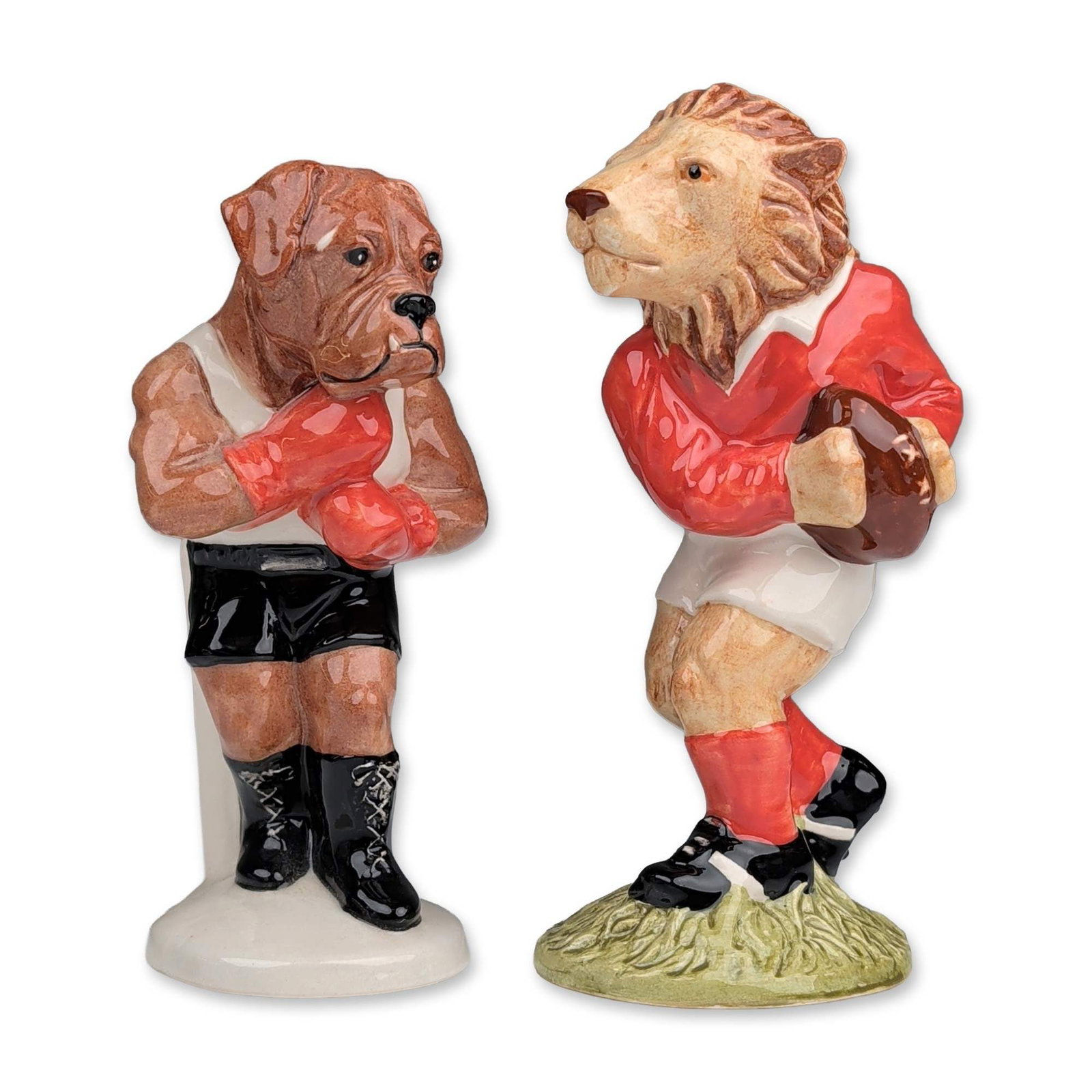 2pc Beswick Royal Doulton Sporting Characters Figurines: Beswick for Royal Doulton. Pair of figurines in glazed ceramic from the Sporting Characters Collection, issued in 1999. Includes The Last Lion of Defence (SC2) featuring an anthropomorphic lion rugby 