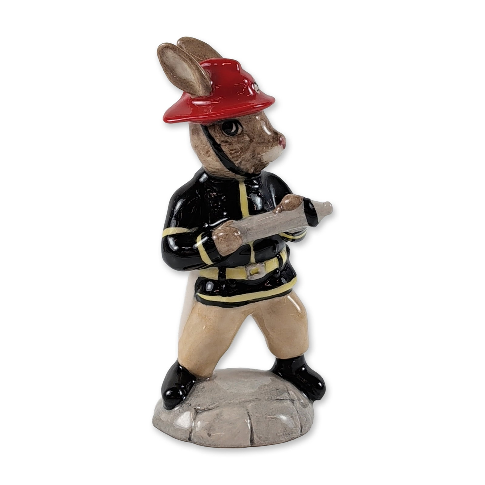 Royal Doulton American Firefighter Bunnykins Figurine: Royal Doulton. American Firefighter Bunnykins figurine, DB 268, in hand-decorated glazed ceramic. The figure depicts a rabbit character in black firefighter turnout gear with yellow reflective stripin