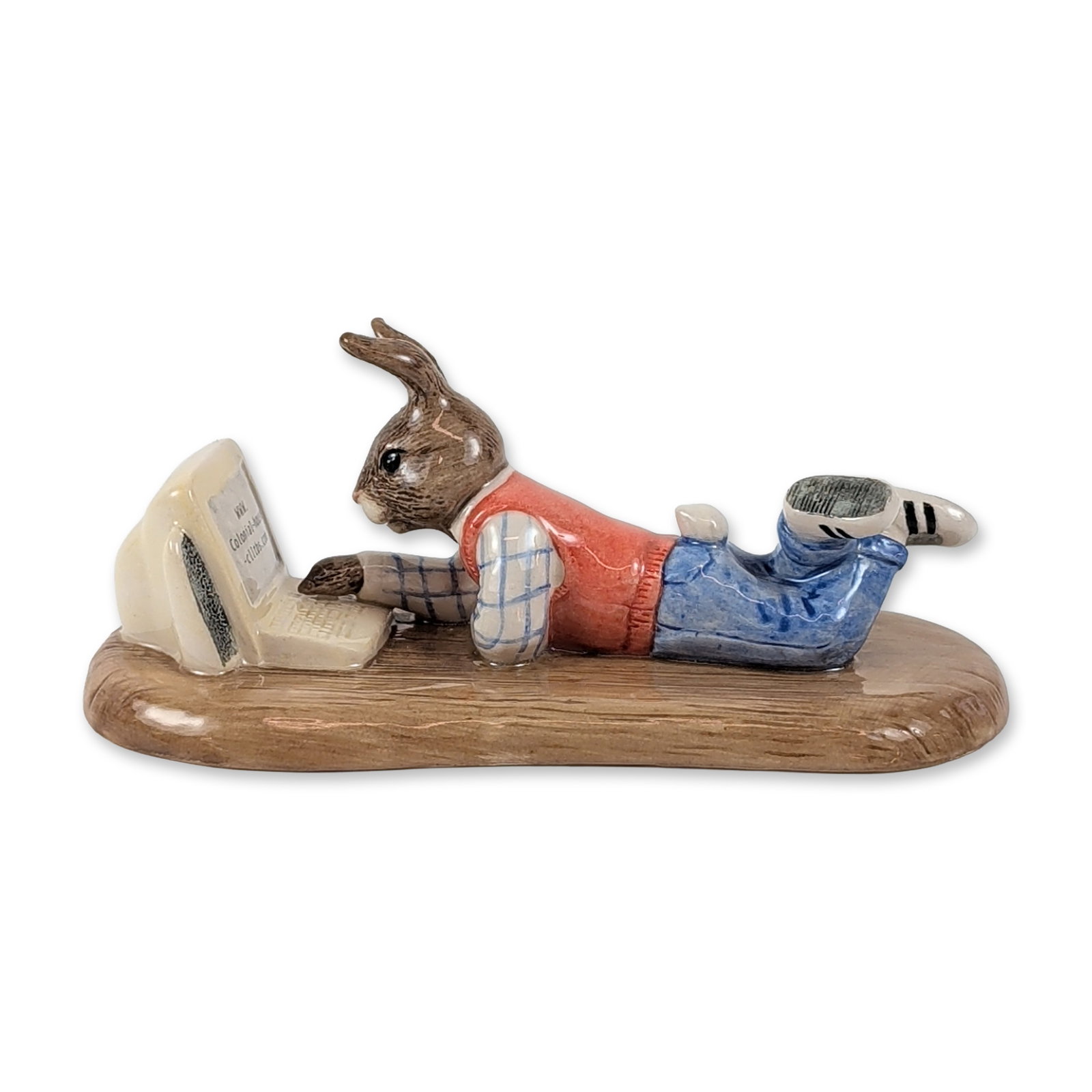 Royal Doulton Bunnykins Porcelain Online Figurine: Royal Doulton Bunnykins figurine titled On Line Bunnykins, model DB 238. The piece depicts a rabbit in a prone position operating a desktop computer, dressed in a red sweater vest over a checkered shi