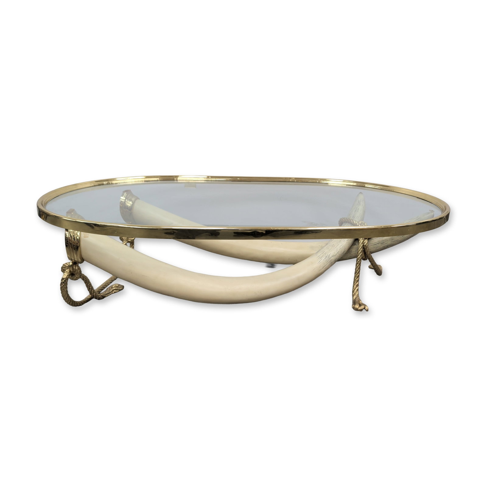 Italo Valenti (Spanish 1912-1995), Gilded Metal and Faux Elephant Tusks Coffee Table: Italo Valenti for Valenti, Spain, 1970s coffee table featuring an oval inset glass top within a heavy polished gilded metal frame. The base is composed of two large crossed faux elephant tusks, suppor