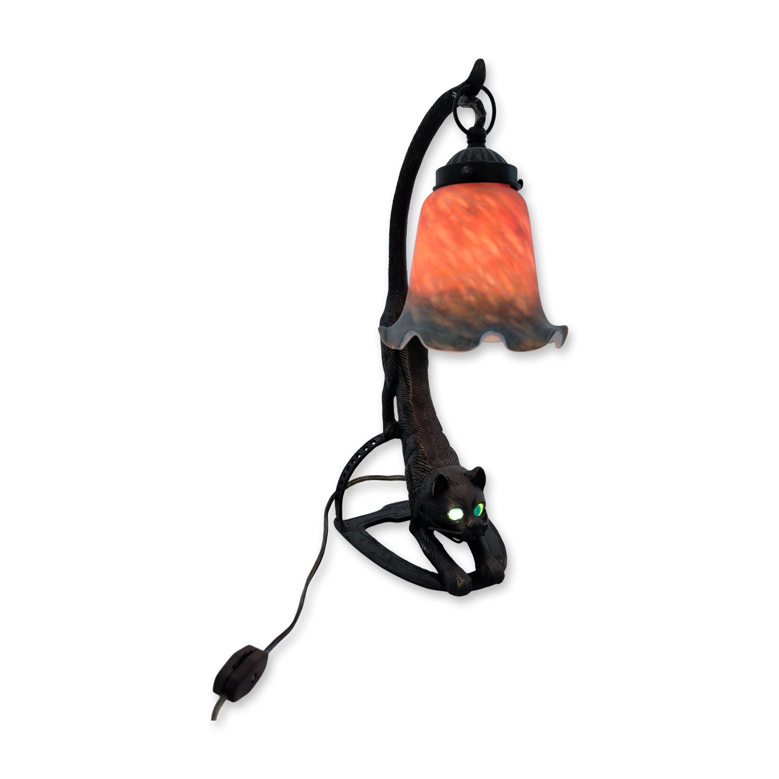 Art Deco Cat Table Lamp: Art Deco table lamp in cast metal and art glass, featuring a base modeled as a stretching cat with its tail supporting the lamp socket. The cat is inset with translucent green eyes that illuminate. Th