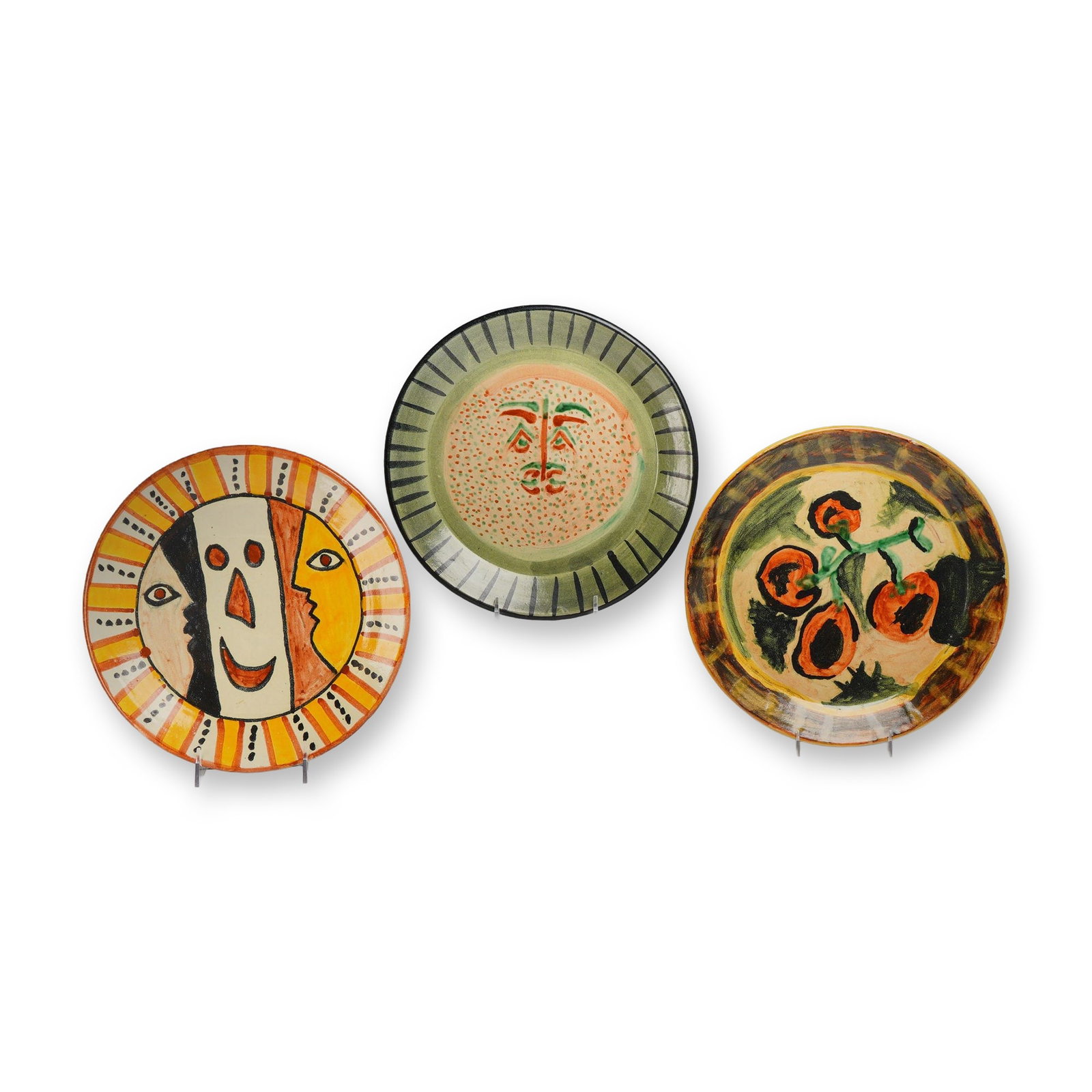 Three Picasso-Inspired Earthenware Plates: A trio of glazed earthenware plates featuring Modernist designs inspired by the ceramic works of Pablo Picasso. Each plate displays a unique hand-painted motif rendered in colorful glazes. One plate f