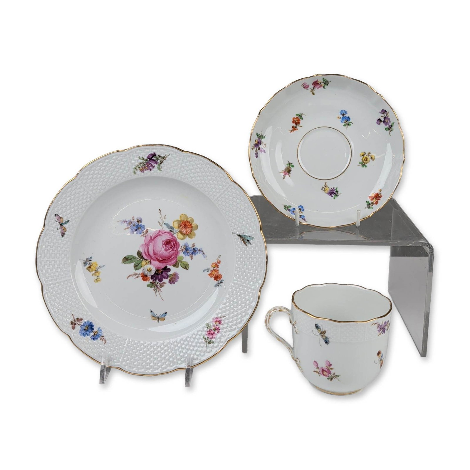 3pc Meissen German Flowers Porcelain Tea Trio: A three-piece Meissen porcelain tea trio, comprising a teacup, saucer, and dessert plate. Each piece is hand-painted in polychrome enamels with Deutsche Blumen floral sprays and scattered insect motif