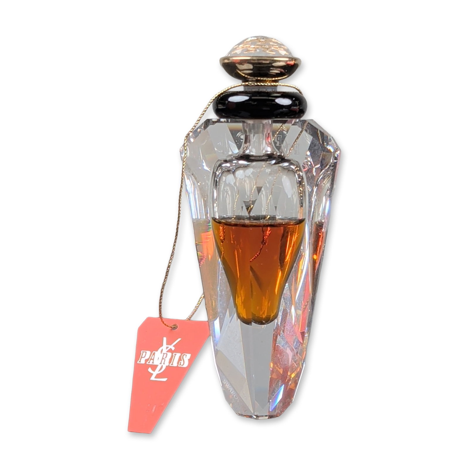 Yves Saint Laurent Swarovski Crystal Paris Parfum Flacon: Yves Saint Laurent limited edition commemorative Paris Parfum flacon in faceted Swarovski crystal. The design features a clear multi-faceted body with a teardrop-shaped inner reservoir containing ambe