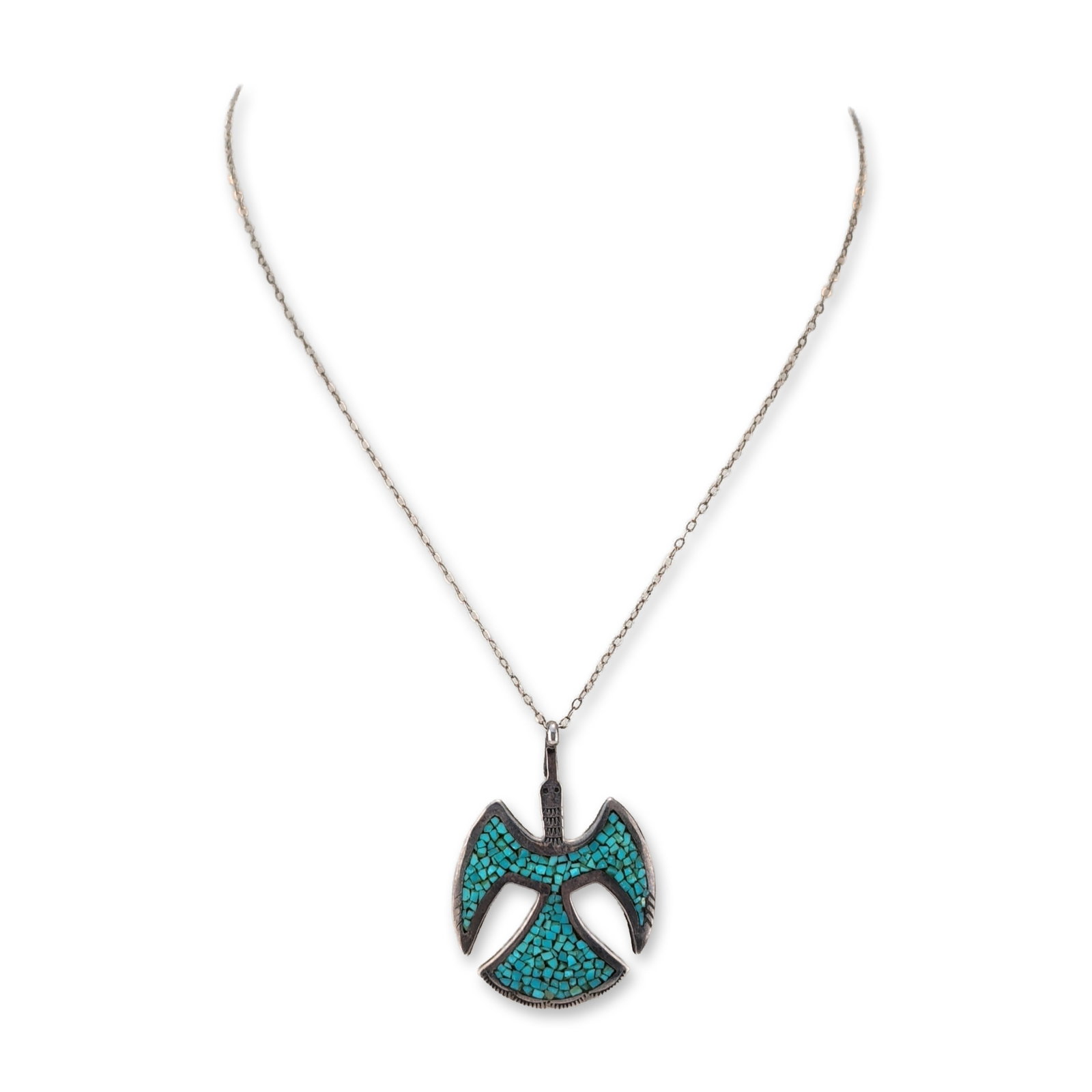 Sterling Silver Turquoise Thunderbird Pendant Necklace: Southwest style thunderbird pendant and necklace in sterling silver, featuring turquoise chip inlay throughout the body, wings, and tail sections. The stylized avian form is detailed with stamped geom
