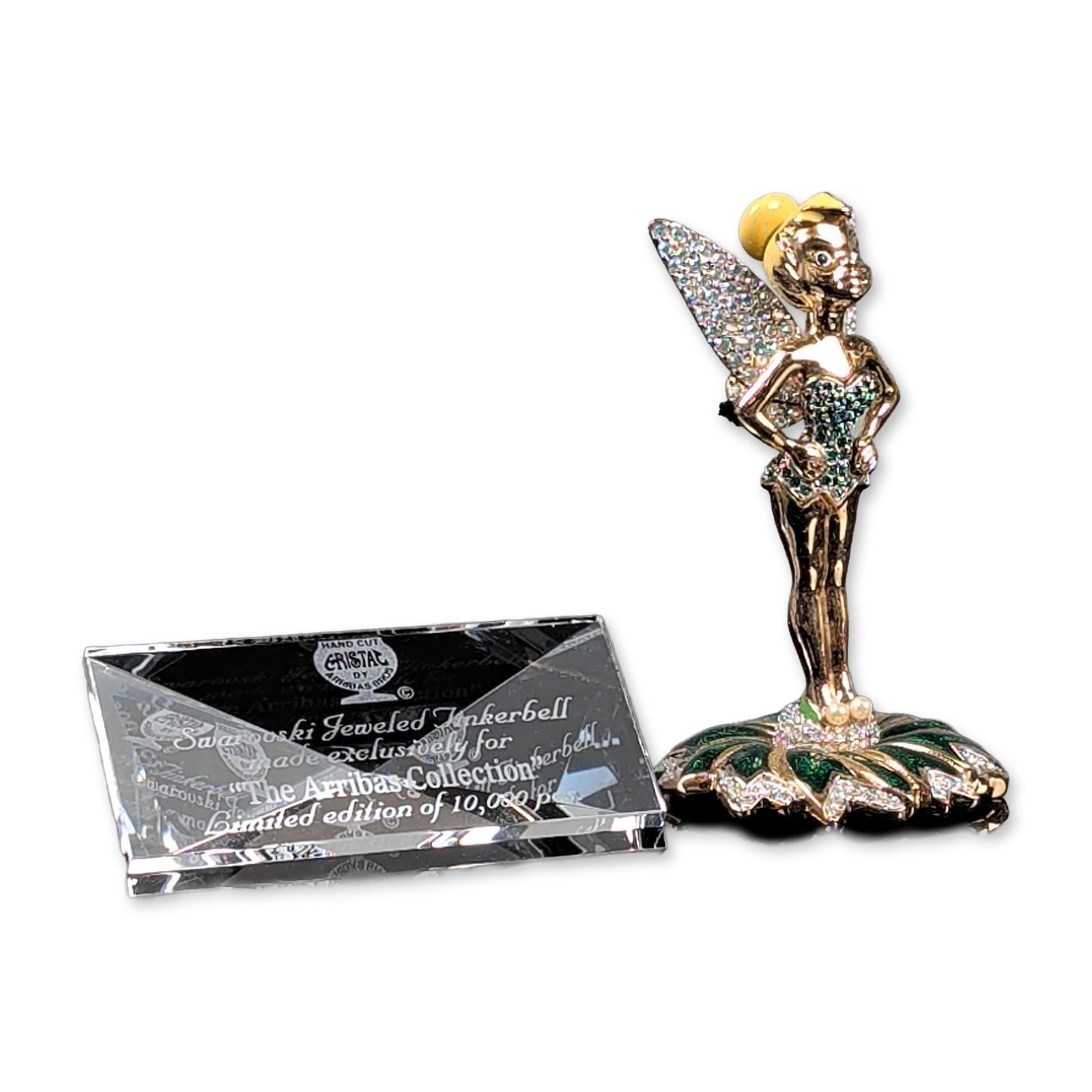 2pc Arribas Brothers Swarovski Jeweled Tinkerbell Figurine and Title Plaque: Arribas Brothers Disney Tinkerbell figurine from The Arribas Collection, produced in collaboration with Swarovski. The gold-tone metal figure depicts the character in a reclining pose atop a stylized