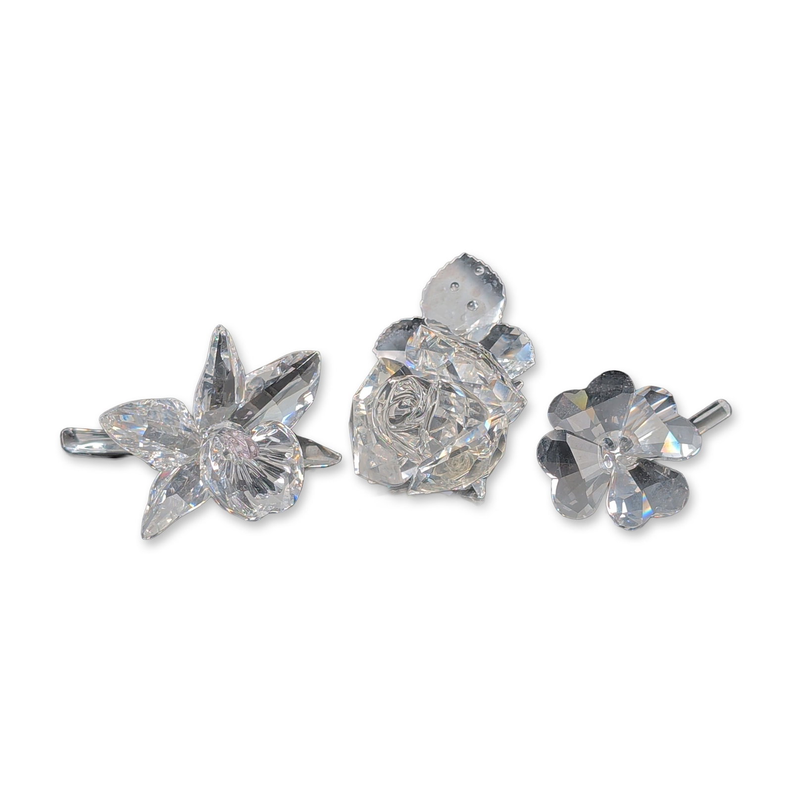 3pc Swarovski Silver Crystal Orchid, Clover and Rose Figurines: Three floral figurines in faceted lead crystal, each piece is designed with multi-faceted petals and clear crystal stems. Accompanied by original manufacturer packaging consisting of three grey cylind