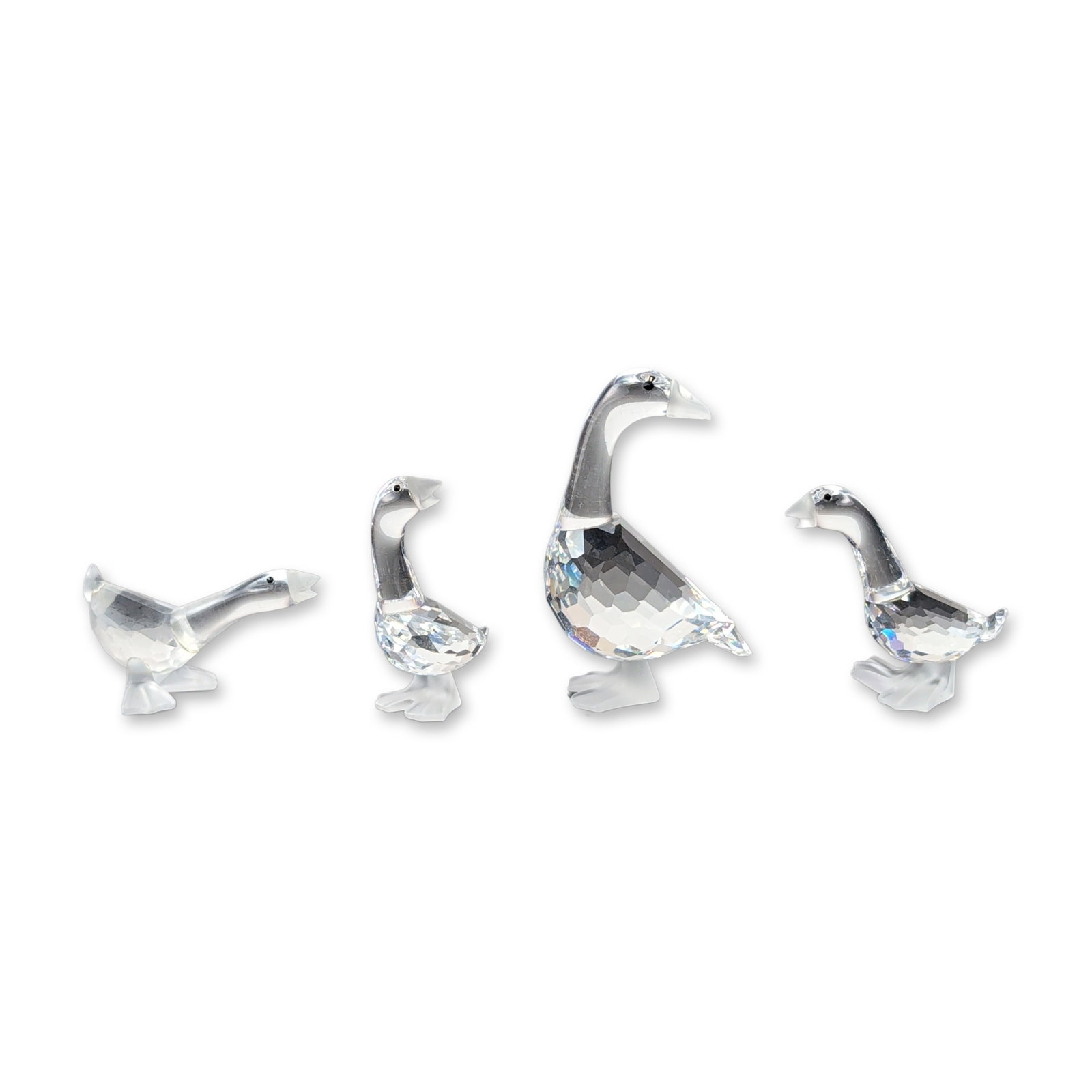 4pc Swarovski Silver Crystal Mother Goose Figurines: Swarovski Silver Crystal collection set of four figurines, comprising the Mother Goose and three graduated goslings known as Tom, Dick, and Harry. The figures are constructed from faceted lead crystal