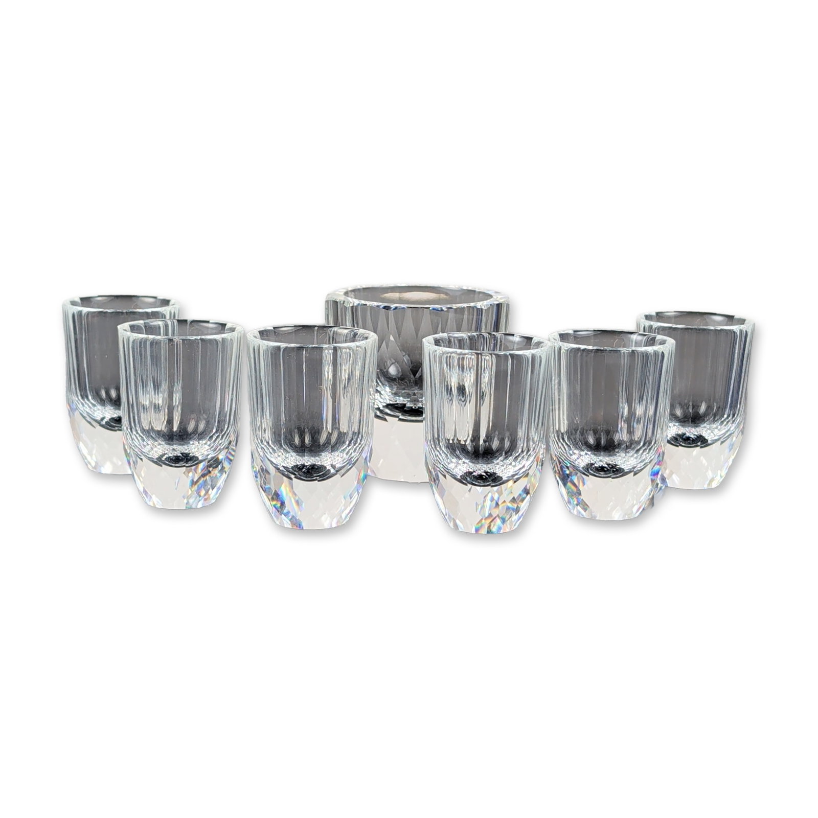 7pc Swarovski Miniature Crystal Candle Holder and Shot Glasses: This Swarovski crystal tabletop collection includes a larger candle holder accented with elegant vertical fluting and brilliant diamond-cut facets. Accompanying the holder are six matching smaller