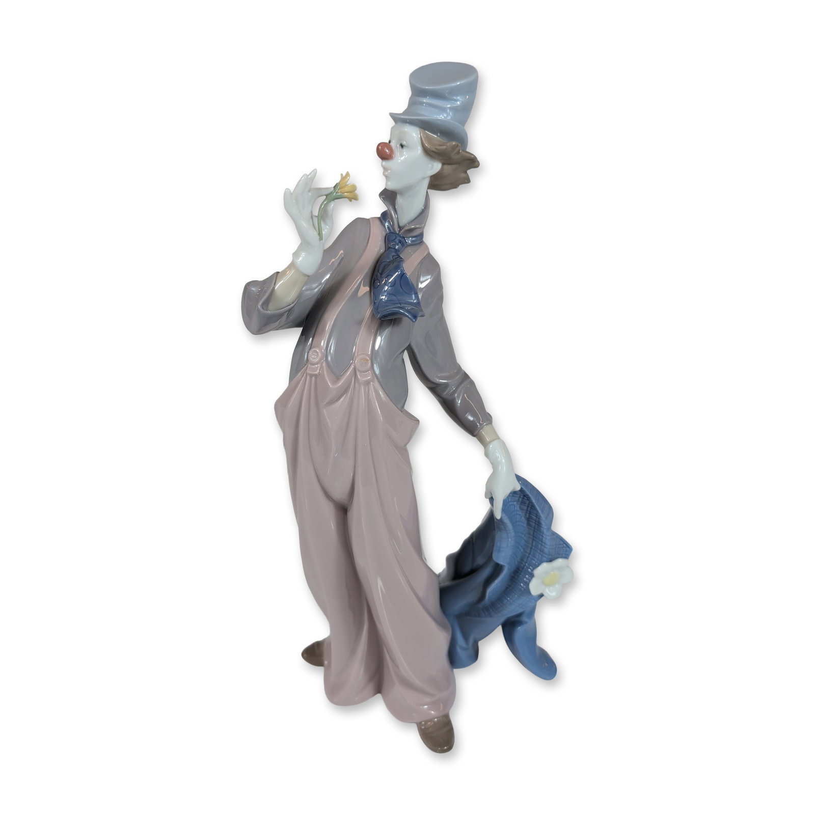 Lladro A Mile of Style Porcelain Clown Figurine 6507: Lladro Spanish porcelain figurine, model 6507, titled A Mile of Style. The figure depicts a pensive clown in a blue top hat, grey shirt, and pink-beige overalls, holding a small yellow flower in one