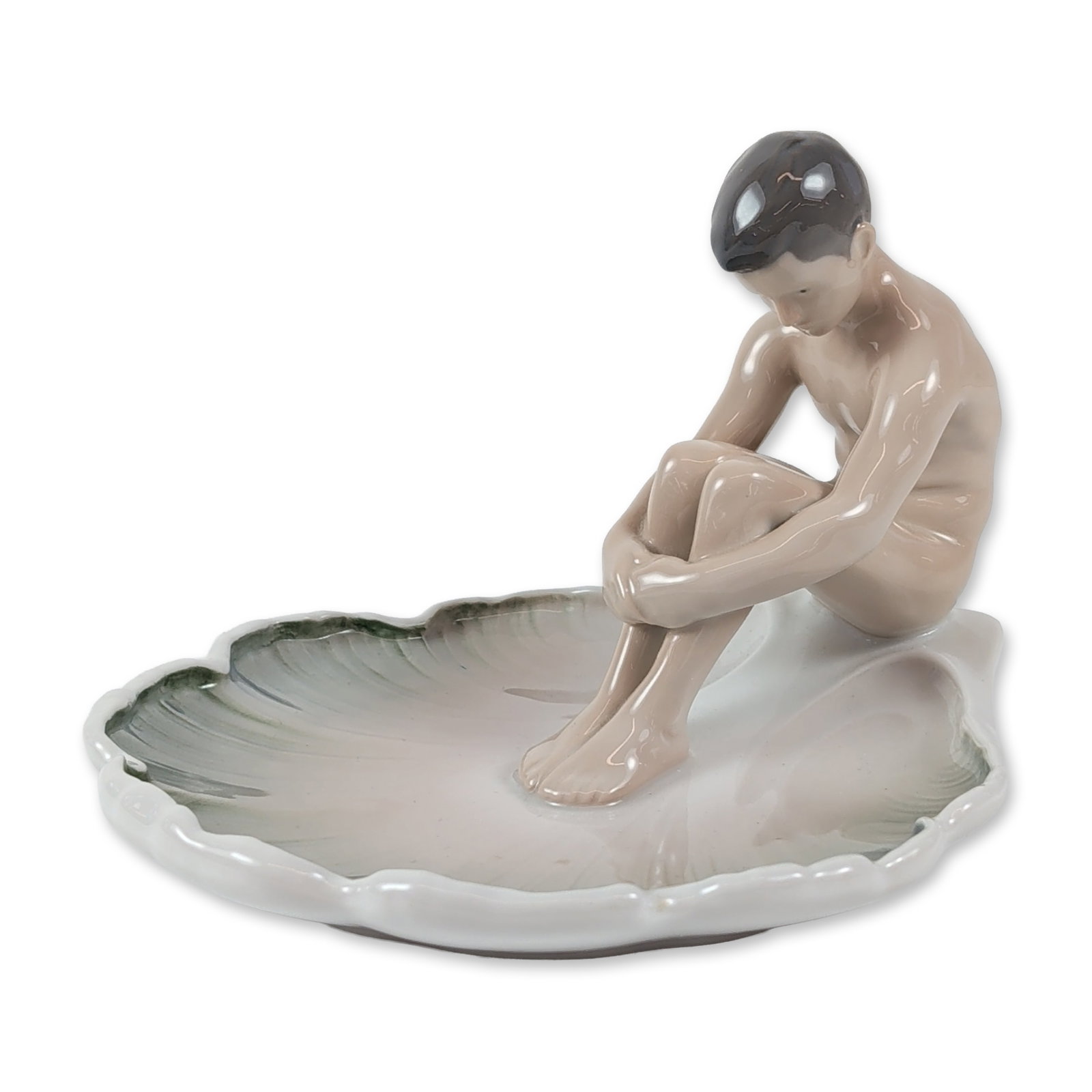 Bing & Grondahl Porcelain Boy on Lily Pad Figurine: Bing & Grondahl Danish porcelain figurine titled Boy on Lily Pad, model number 1660. Designed by Ingeborg Irminger, the piece depicts a nude young boy in a crouched pose seated on a large lily pad lea