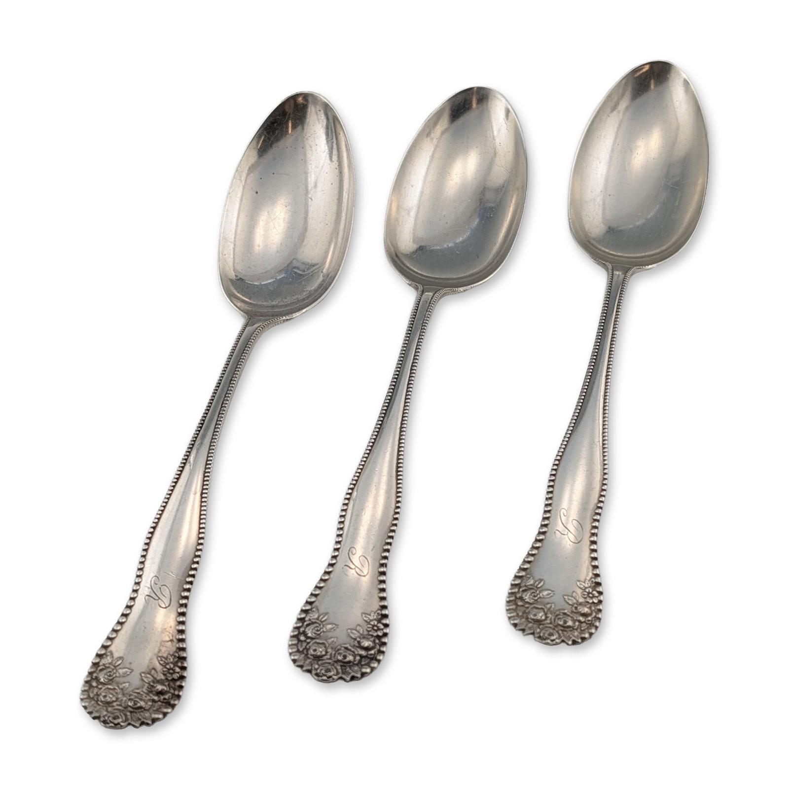 Trio of Gorham Lancaster Sterling Silver Serving Spoons: Sterling silver serving spoons in the Lancaster pattern by Gorham. Each tablespoon features a beaded handle border terminating in a high-relief cluster of roses and leaves. The front of each handle is