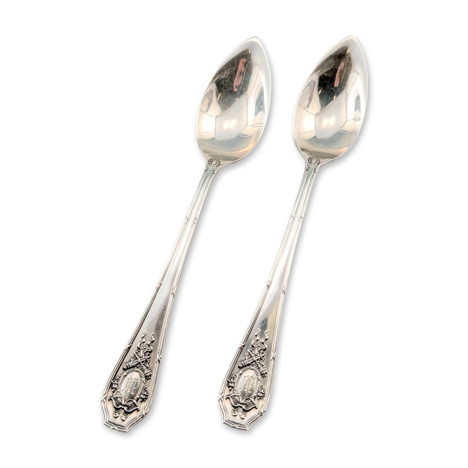 2pc Wallace Sterling Silver Citrus Spoons: R. Wallace and Sons. Pair of citrus or grapefruit spoons in sterling silver. Each piece is designed with a pointed bowl and a decorative handle displaying a central oval cartouche surmounted by a ribb