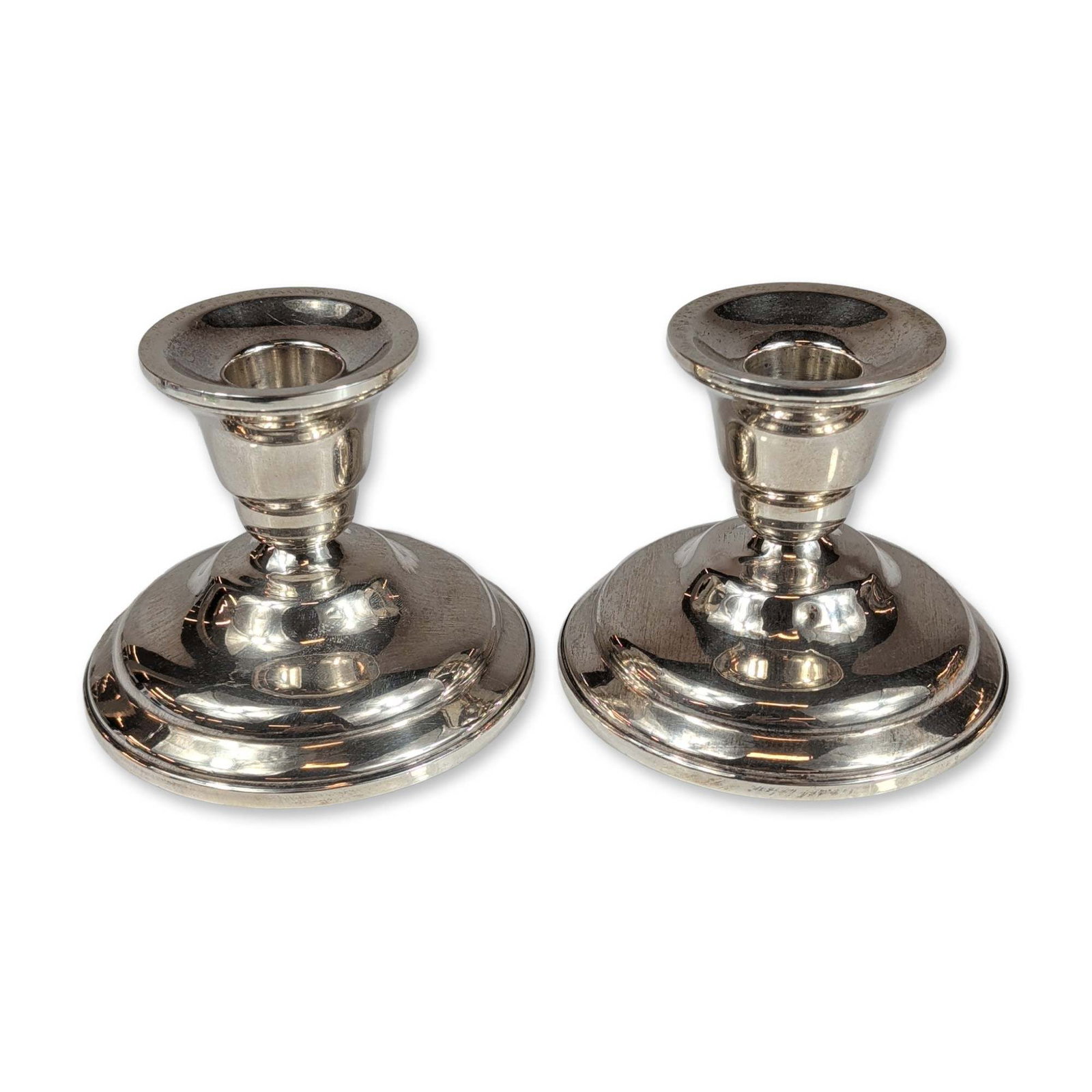 Pair of Shreve, Crump & Low Co. Sterling Silver Weighted Candlesticks: American weighted sterling silver candlesticks manufactured by Shreve, Crump & Low Co. Each piece features a stepped circular base with a short stem and flared cup. Marked to the underside with Shreve