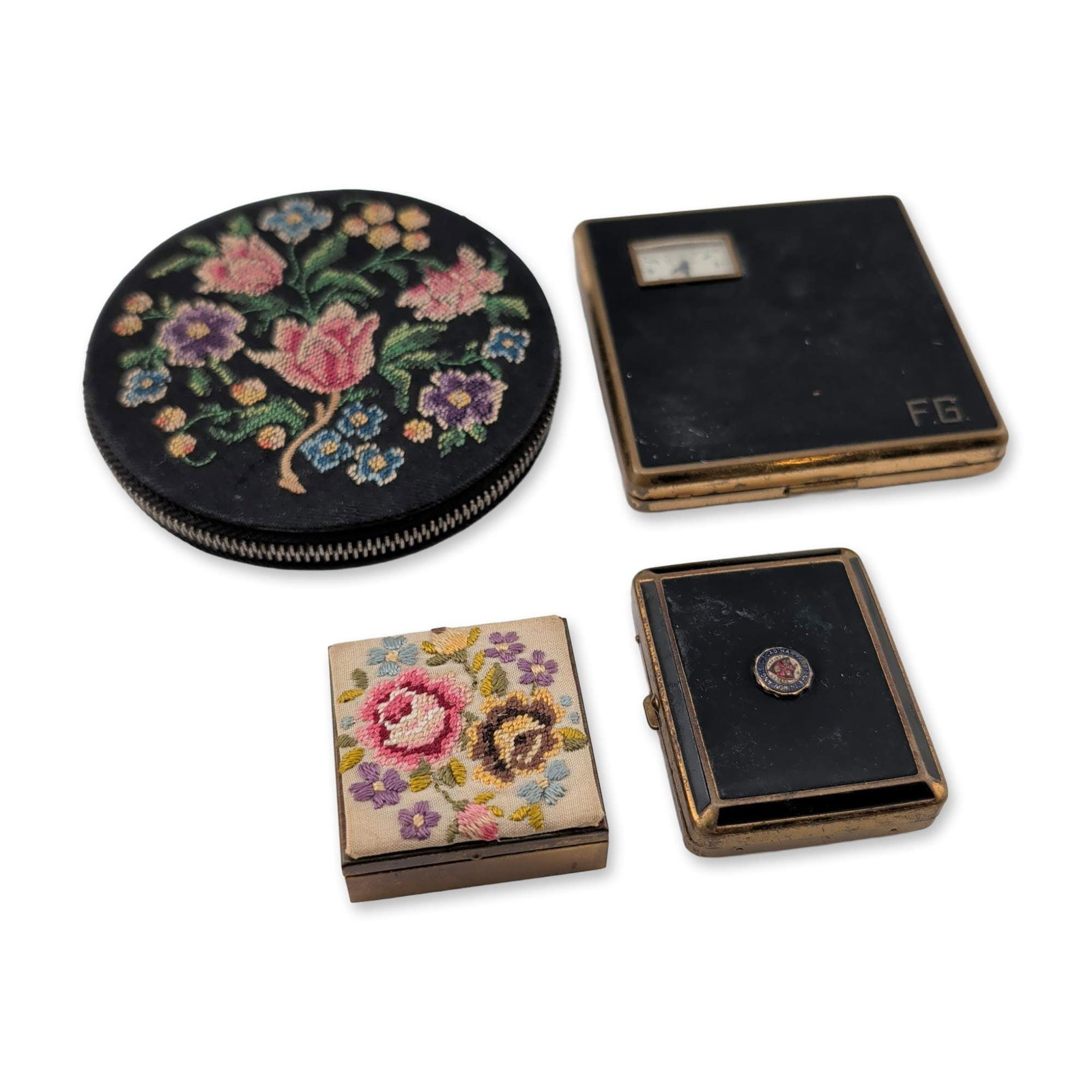 4pc Vintage Enamel and Embroidered Compacts and Jewelry Box: A group of four vintage cosmetic vanity items including embroidered and enameled examples. The lot includes a round zippered powder case in black leather with a floral needlepoint lid, interior mirror