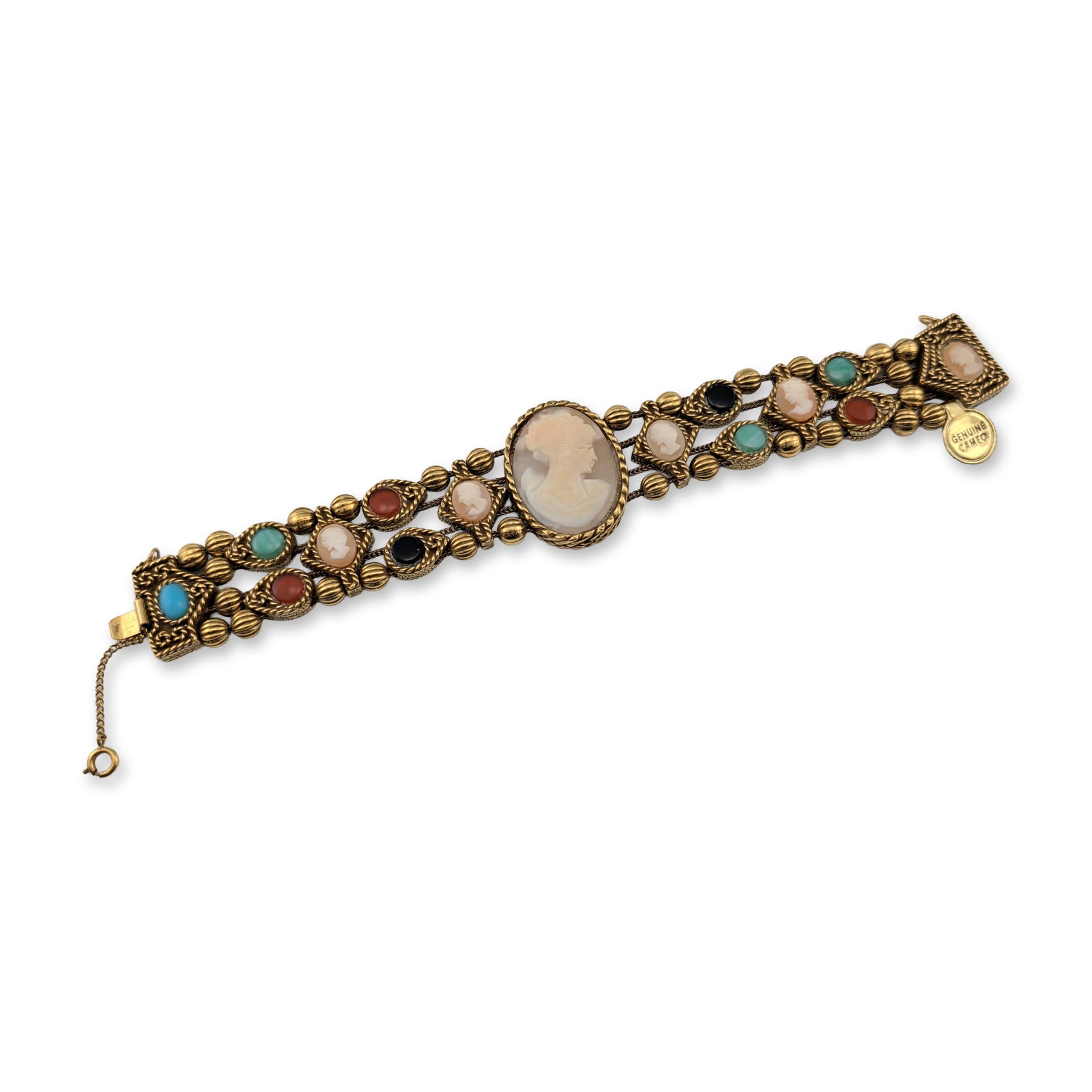 Multi-Strand Shell Cameo Bracelet: Mid-20th century Victorian revival style bracelet. It features a multi-strand construction in gold-tone base metal featuring a central oval hand-carved shell cameo and six smaller shell cameos, all de