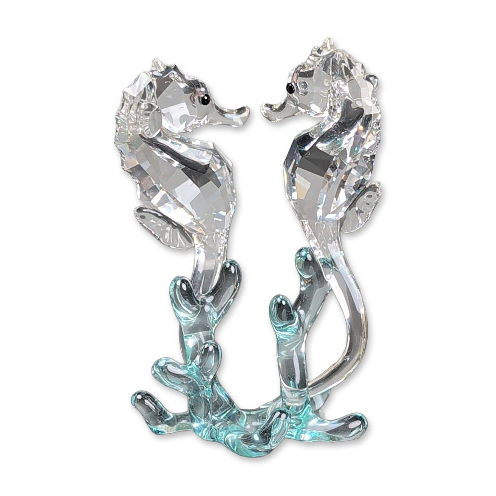 Swarovski Crystal Figurine, Seahorses: Swarovski crystal figurine part of the Aquatic Worlds collection. Two seahorses with faceted clear crystal bodies and smooth glass tails positioned on a light turquoise-tinted glass coral base. Seahor