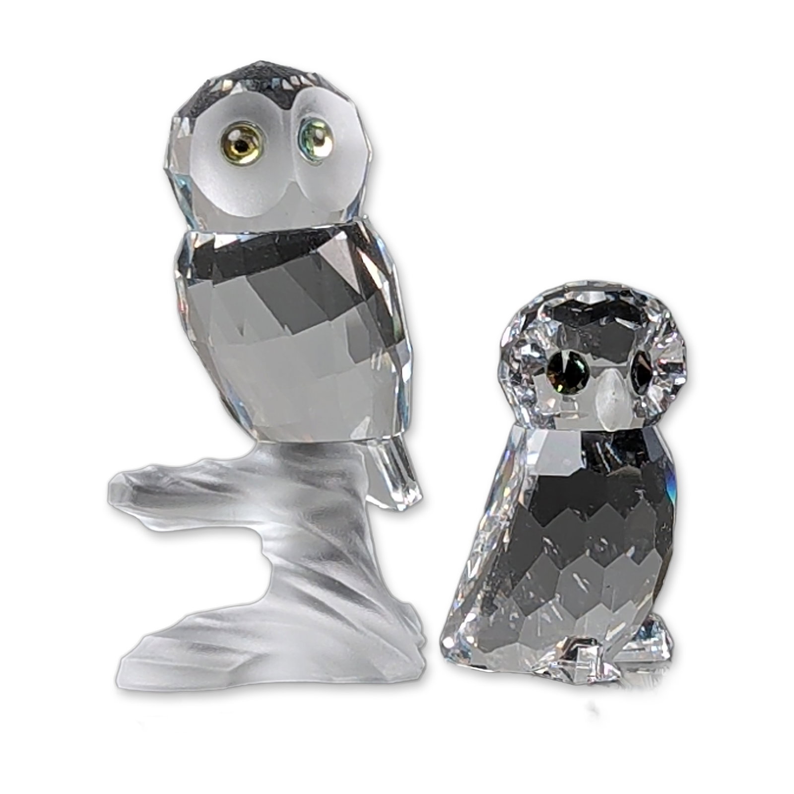 2pc Swarovski Silver Crystal Figurines, Owl and Owlet: Swarovski Silver Crystal faceted lead crystal owl figurines. The lot includes one standing owl figurine with dark inset crystal eyes and one owl figurine perched on a frosted crystal branch with pale 