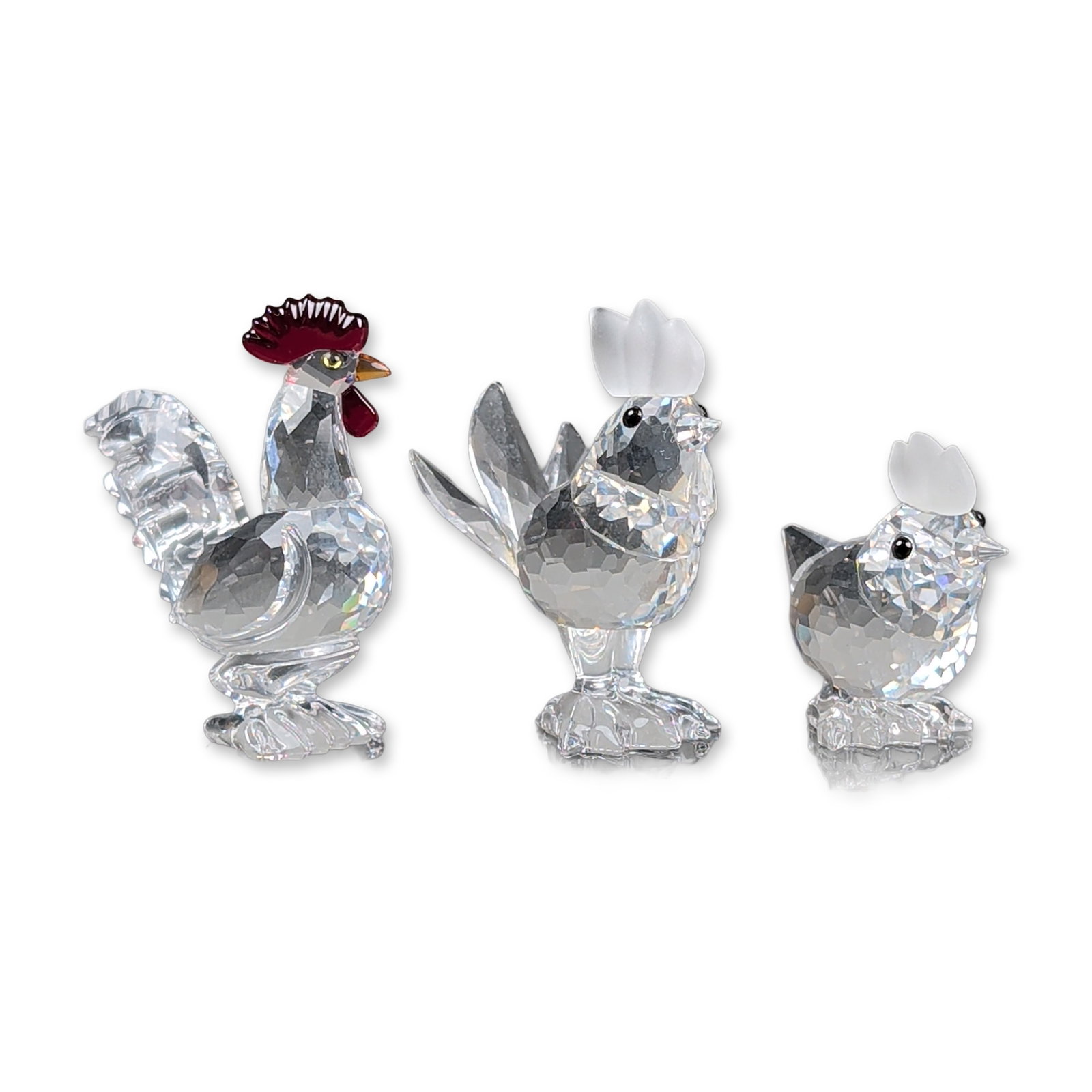 3pc Swarovski Silver Crystal Poultry Figurine: Three Swarovski Silver Crystal of poultry-themed figurines, including a rooster, a hen, and a cockerel. The rooster features a faceted clear crystal body and tail, accented with a red crystal comb and