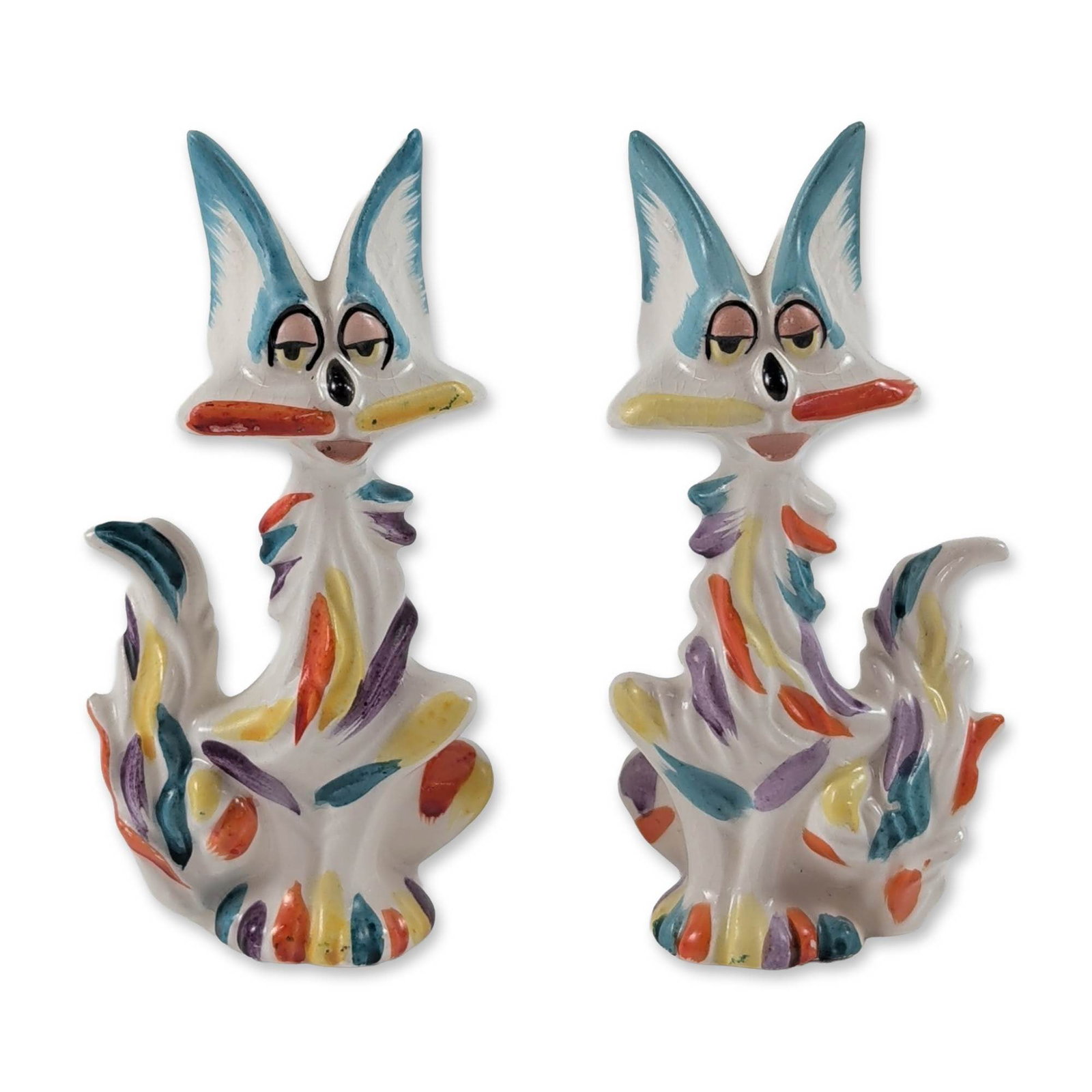 Pair of Mid-Century Modern Ceramic Stylized Fox Shakers: Mid-Century Modern whimsical animal figurines configured as salt and pepper shakers, crafted in glazed white earthenware with hand-painted multi-color confetti-style brushstrokes in blue, orange, yell