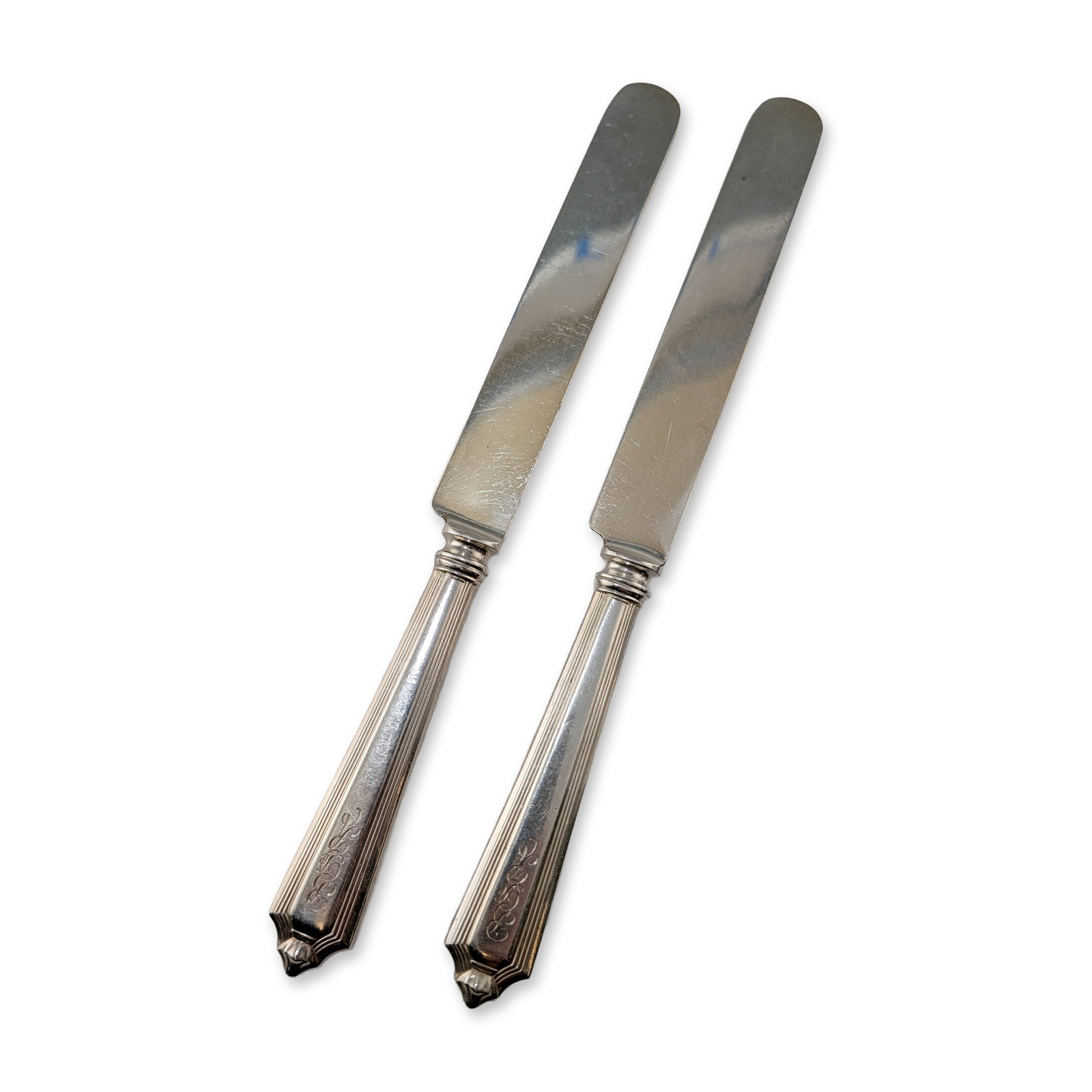 Pair of Gorham Plymouth Sterling Knives: Art Deco designed Gorham Manufacturing Company dinner knives in the Plymouth pattern. Tapered and fluted sterling silver handles with architectural terminals and polished blades. Each handle engraved 