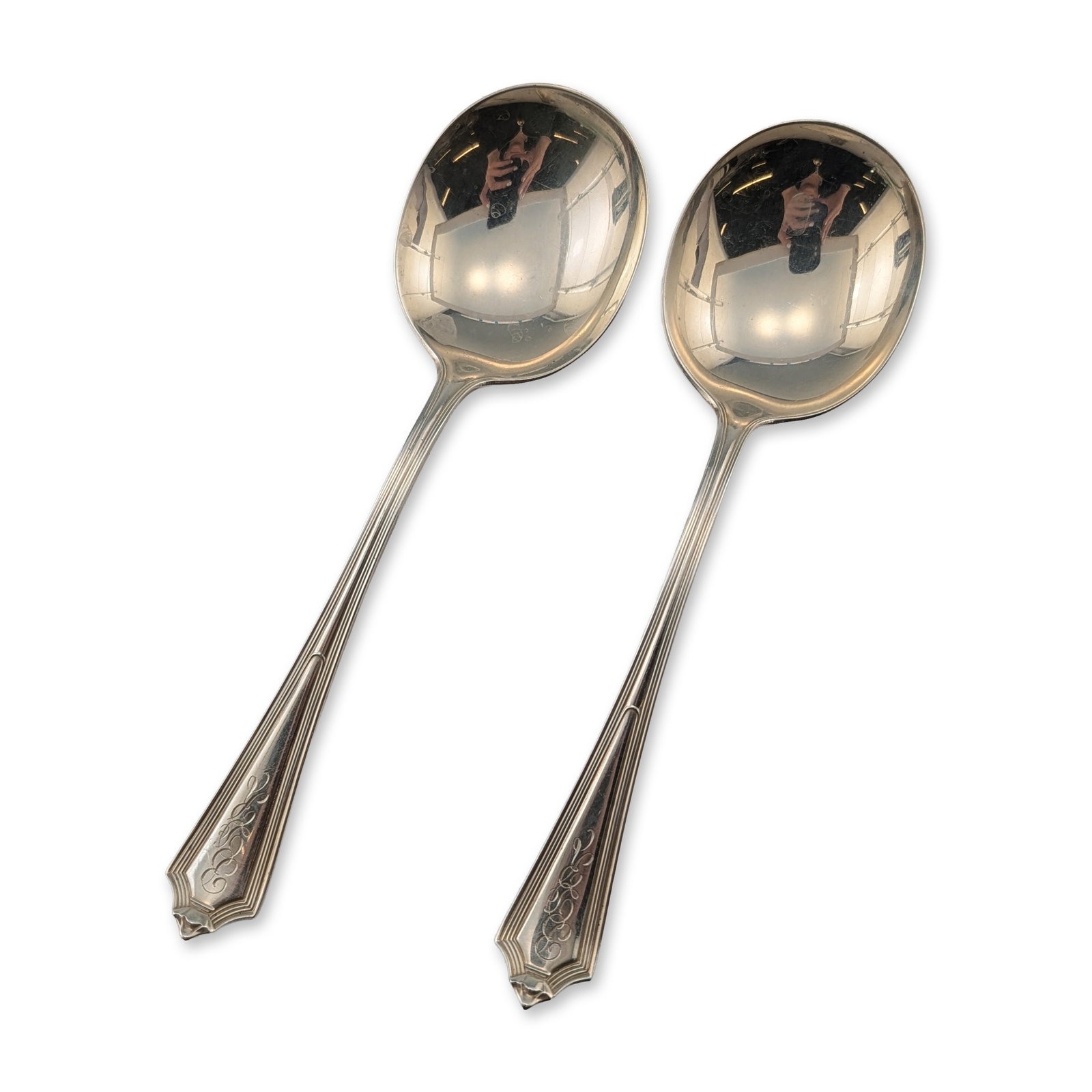 Pair of Gorham Plymouth Sterling Silver Spoons: American Art Deco designed sterling silver spoons by Gorham Manufacturing Company. This pair features a tapered handle design with clipped corners and reeded edge detailing. Each piece is decorated wi