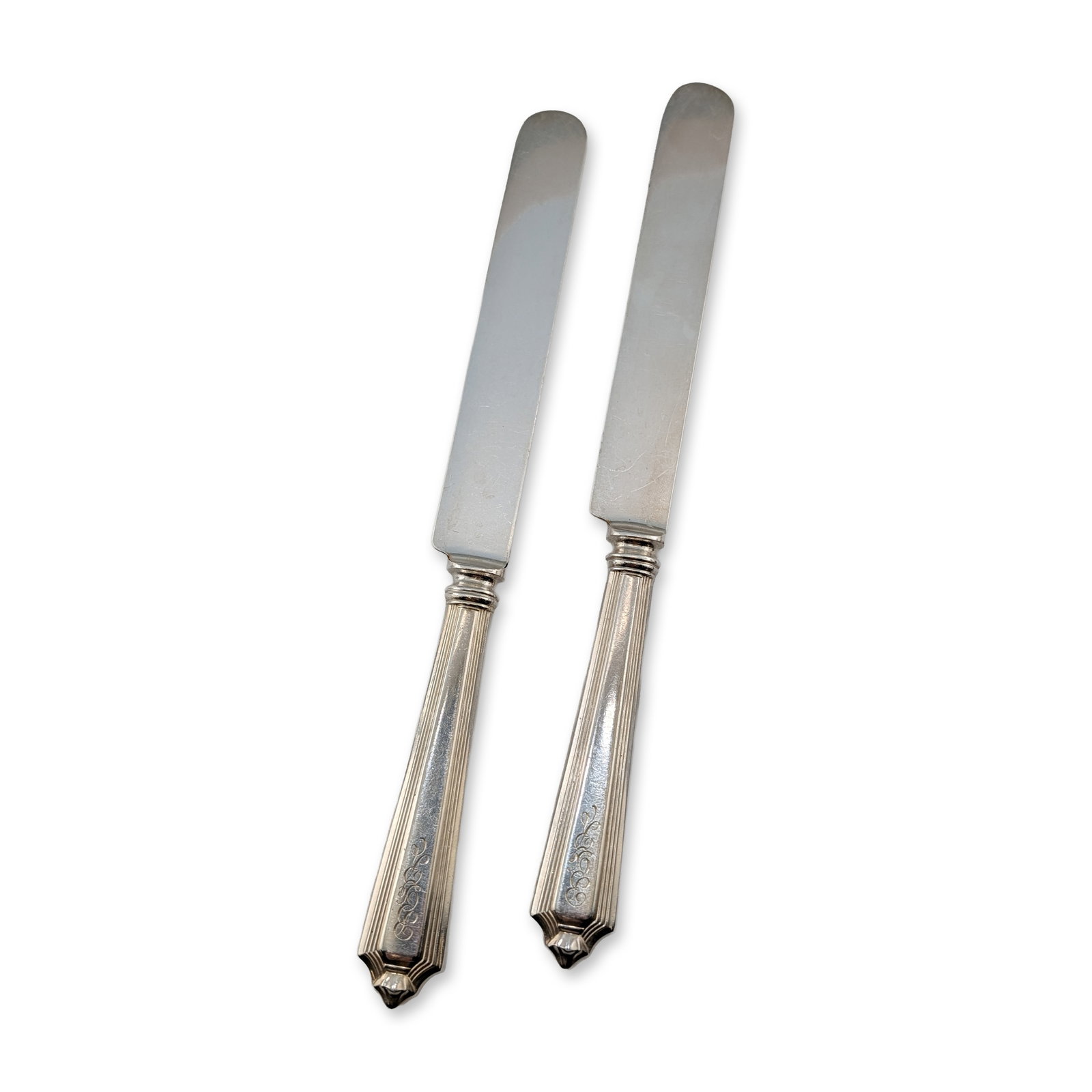 2pc Gorham Plymouth Sterling Silver Handled Dinner Knives: Gorham Manufacturing Company. Pair of dinner knives designed in the Art Deco style, featuring an architectural form with vertical reeding and tiered geometric terminals. The bolster of each handle is 