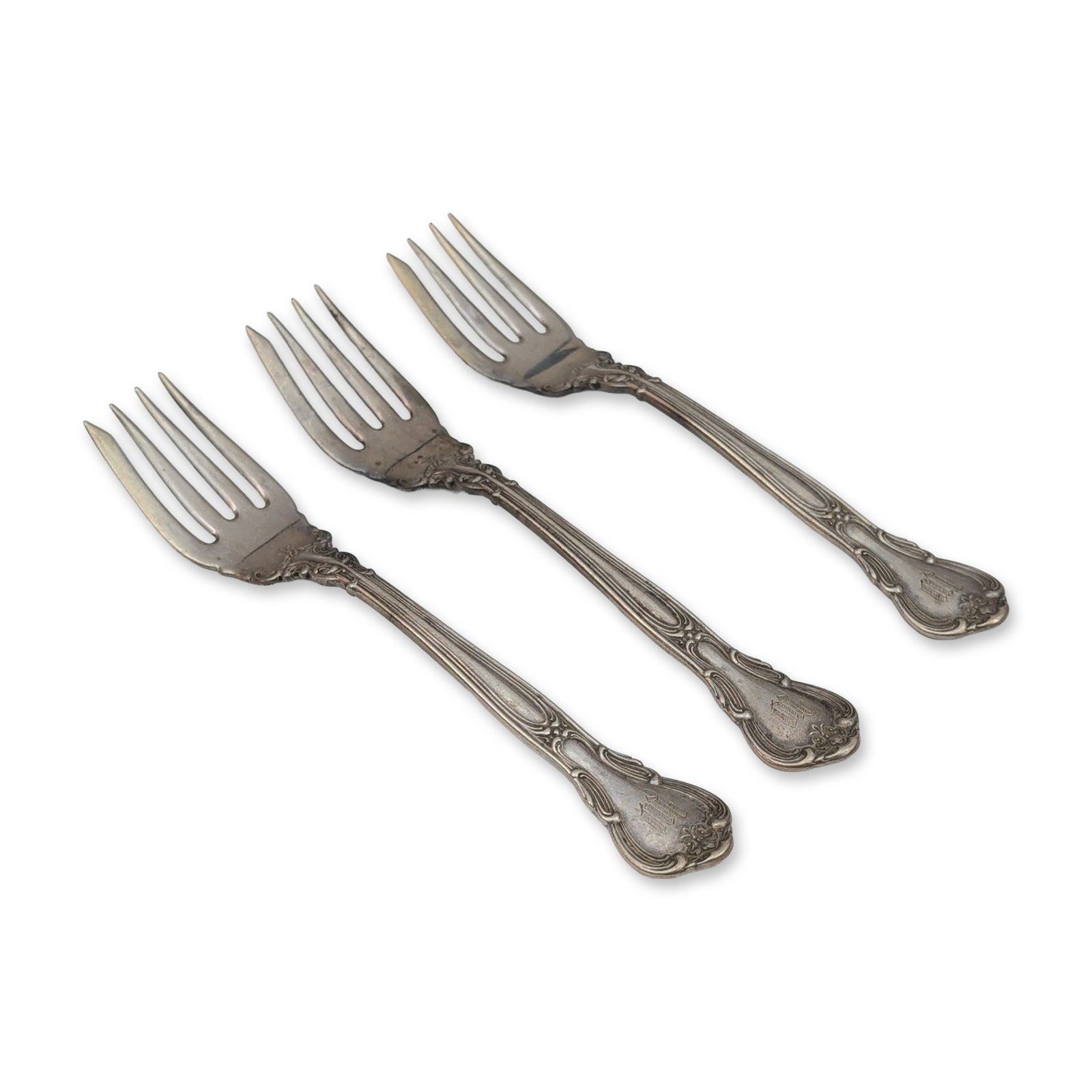 Trio of Gorham Sterling Silver Chantilly Pattern Salad Forks: Sterling silver salad forks in the Chantilly pattern, featuring scrolled edges and an acanthus leaf motif at the junction of the handle and tines. Each handle terminal is engraved with a Gothic-style 