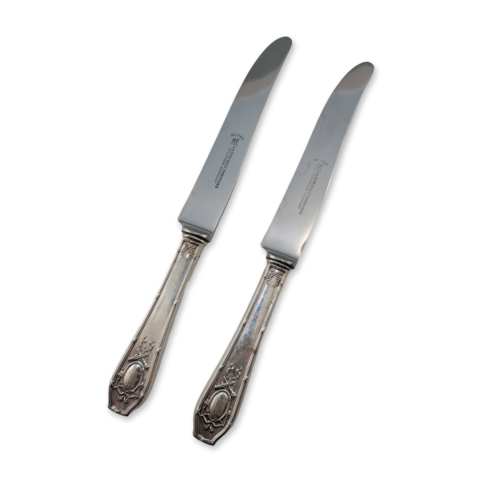 2pc R. Wallace & Sons Sterling Silver Handled Dinner Knives: Neoclassical style dinner knives featuring stainless steel blades and sterling silver handles. The blades are stamped with the J.A. Henckels Twinworks trademark, Solingen, Germany, and No-Stain. The h
