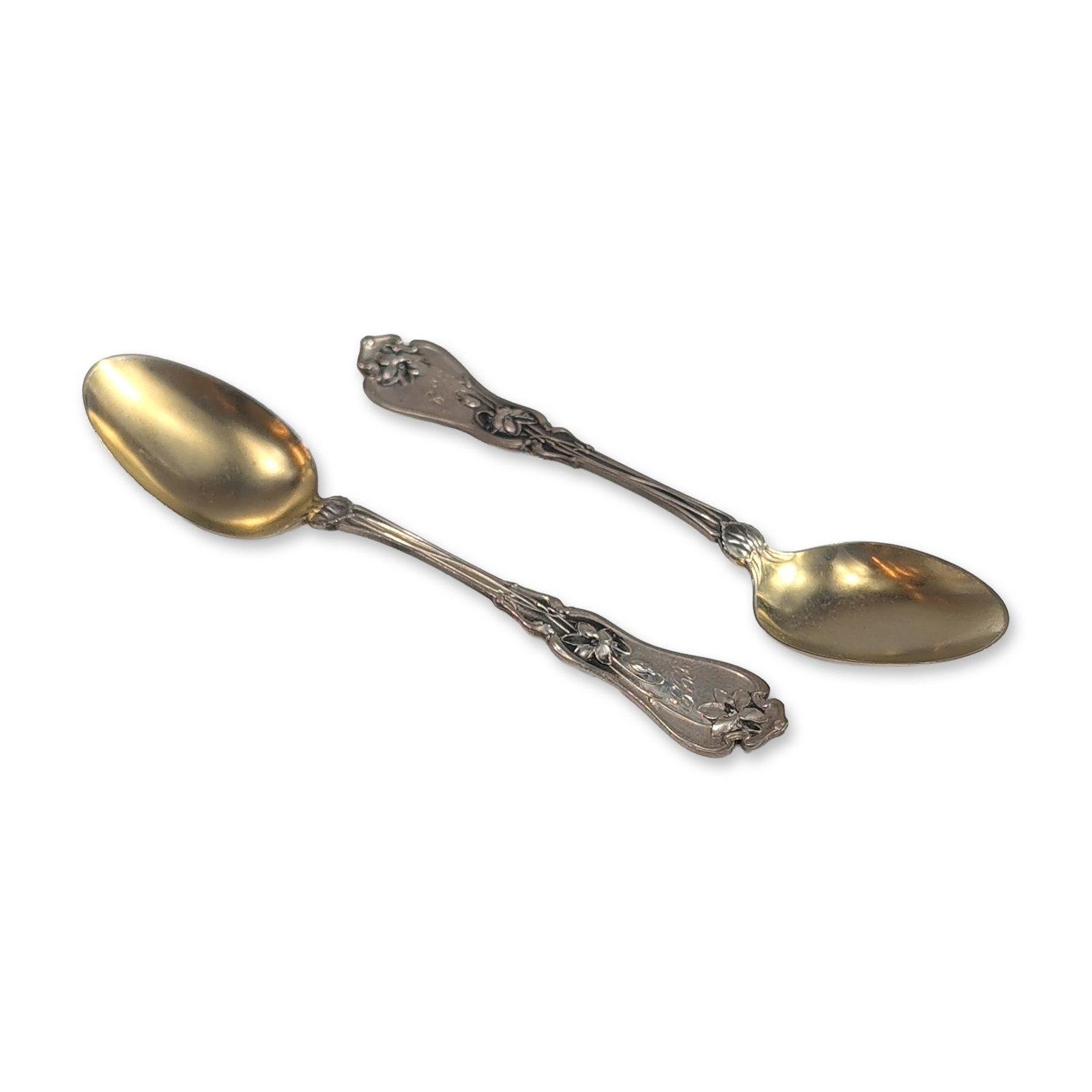 Whiting Art Nouveau Sterling Silver Lily Pattern Demitasse Spoons: Pair of sterling silver spoons in the Lily pattern, featuring relief floral motifs and sinuous lines to the handles. The bowls are finished with a gold-washed vermeil surface. Stamped to the reverse w