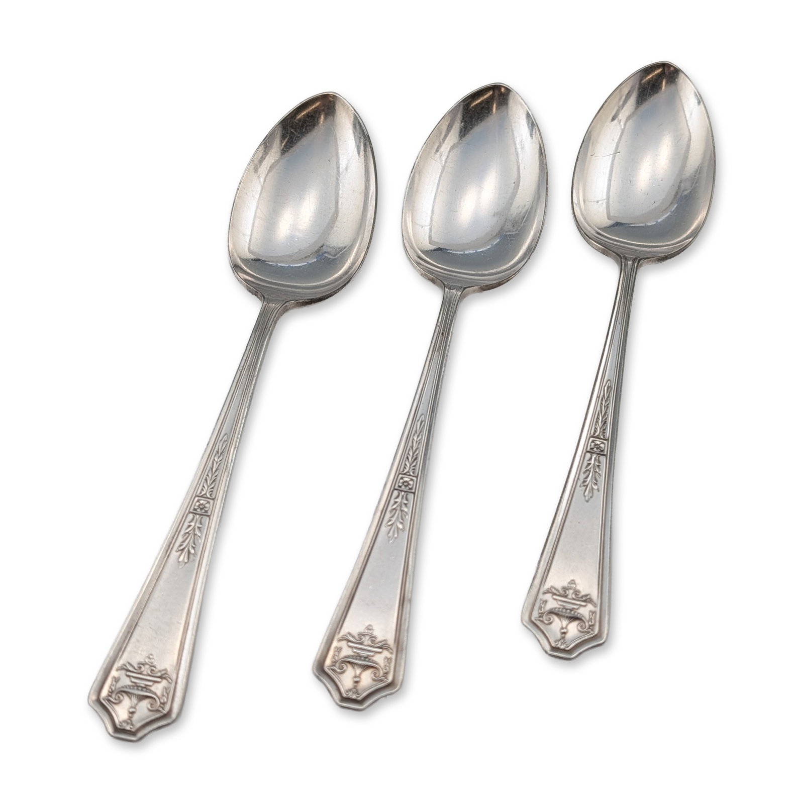 Trio of Simeon L. and George H. Rogers Apollo Silverplate Tablespoons: Simeon L. and George H. Rogers Company. Three tablespoons in silverplate, featuring the Apollo design with a tapered handle decorated with a central urn and trophy motif above a vertical husk stem and