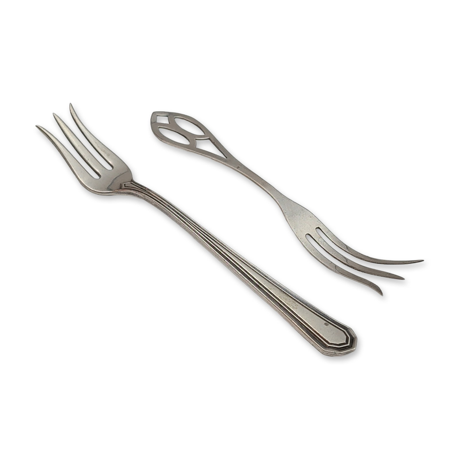 2pc Sterling Silver Lemon Forks includes Webster Company: Both examples constructed of sterling silver. Features a tapered handle with pierced geometric terminal and a stepped, reeded handle with three flared tines. Each piece marked Sterling with respective