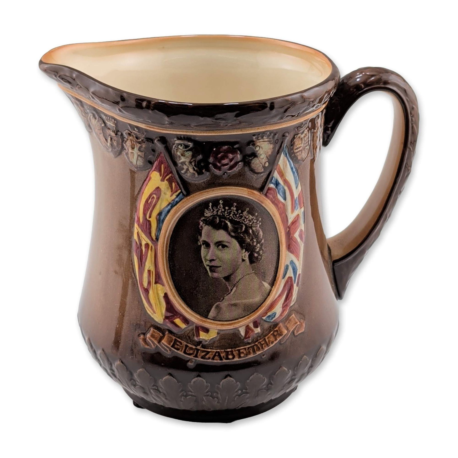 Royal Doulton 1953 Coronation Queen Elizabeth II Glazed Earthenware Pitcher: The vessel is constructed of earthenware with a dark brown high-gloss glaze, featuring a bulbous body, pinched spout, and relief-molded scroll handle. The decoration consists of a polychrome portrait 